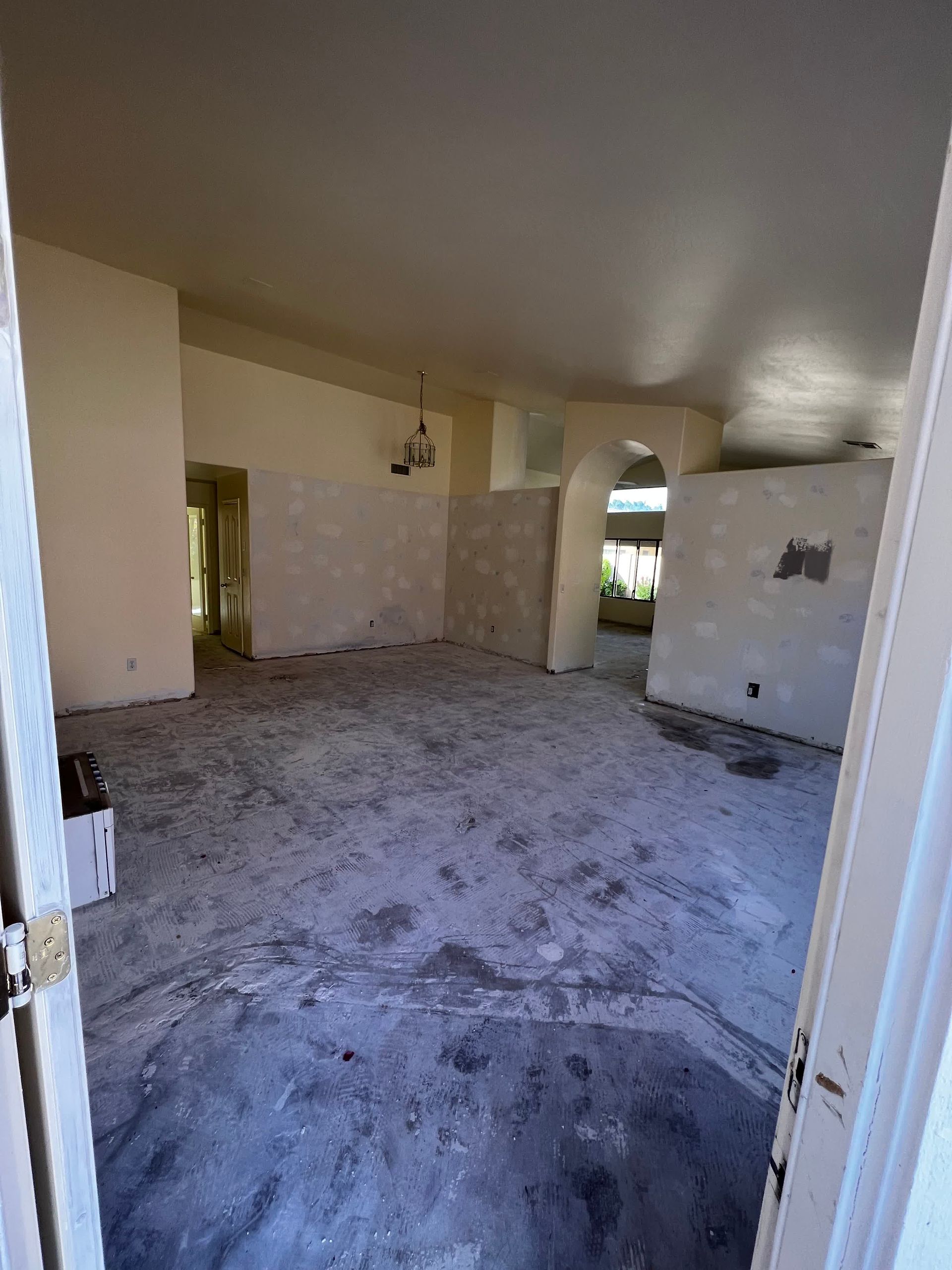 A large empty room with a concrete floor and white walls.