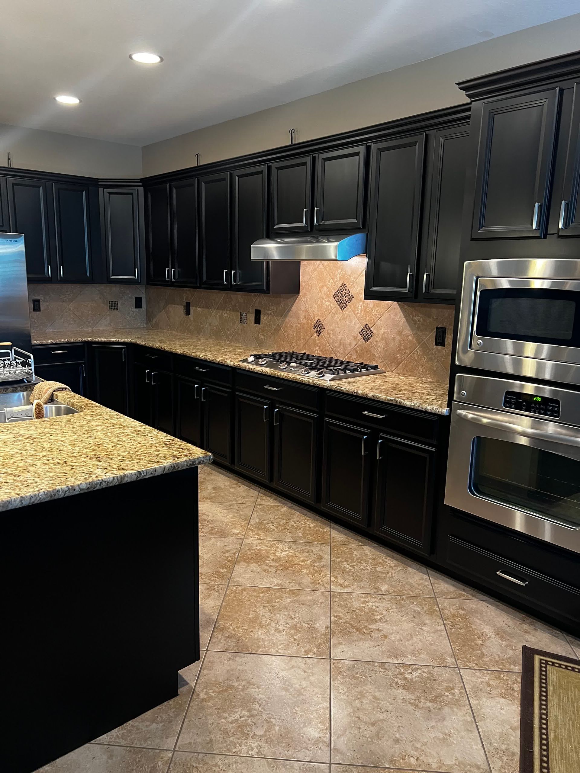 A kitchen with black cabinets and stainless steel appliances