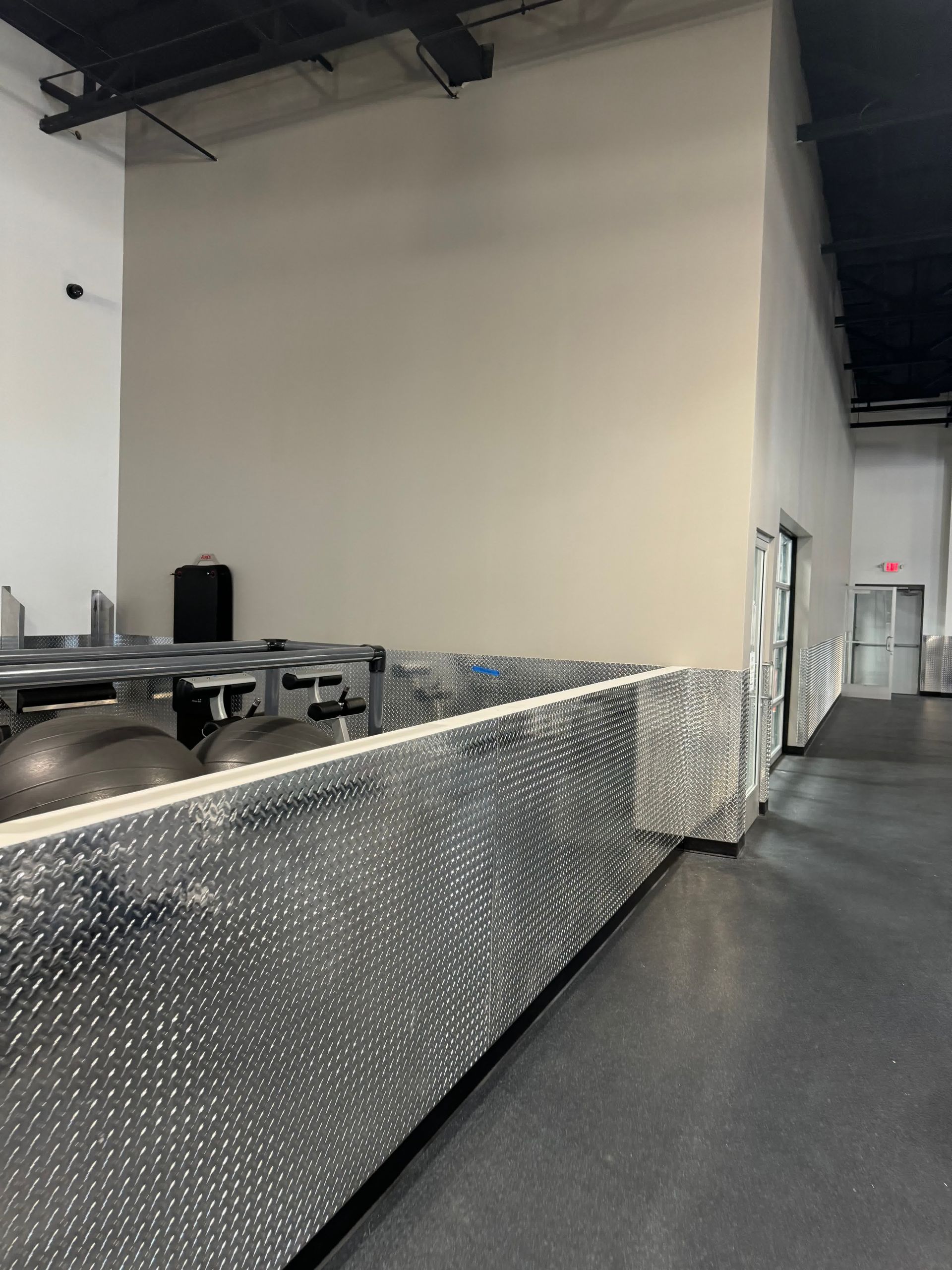 A hallway in a building with a metal fence