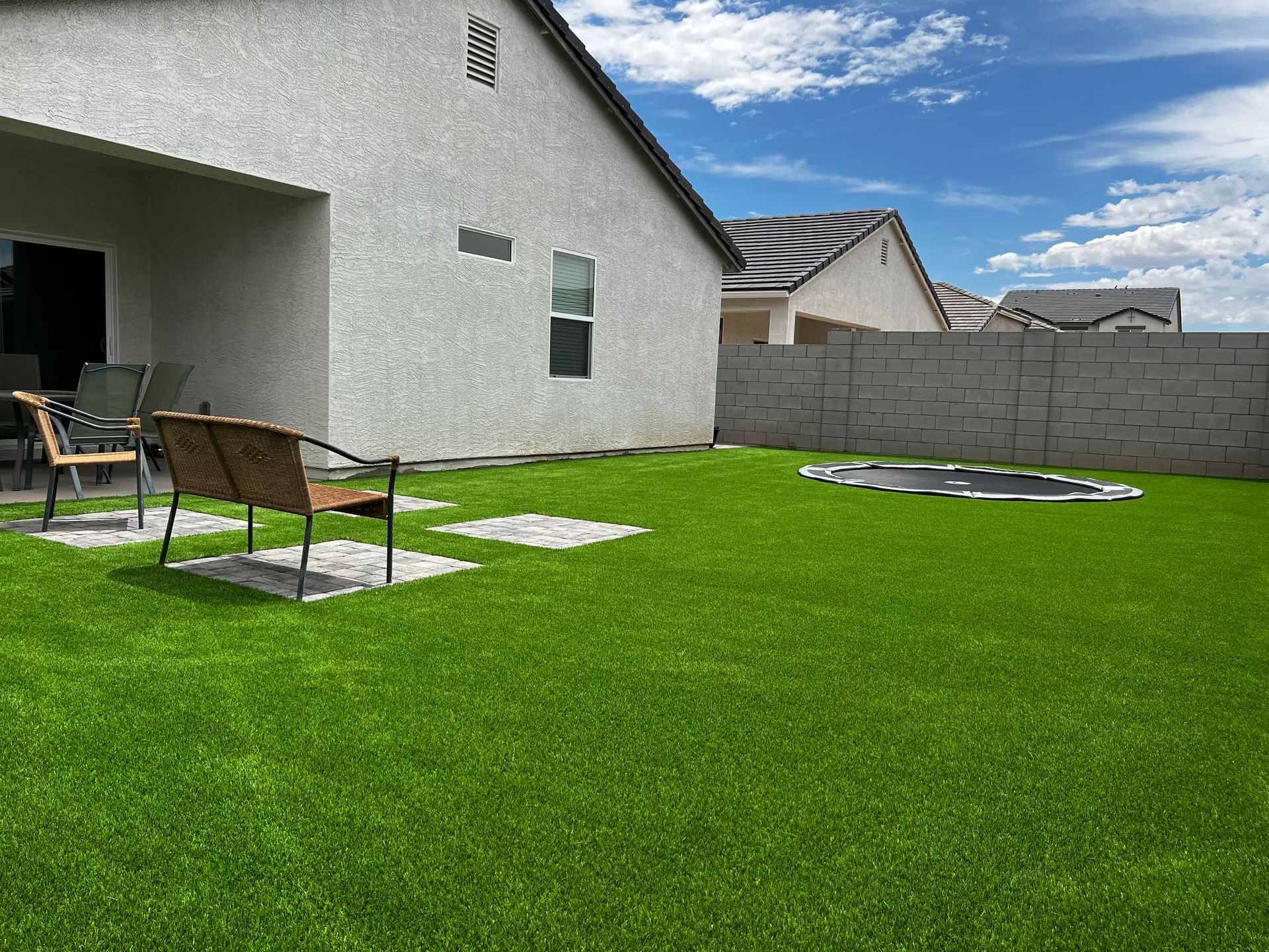 There is a trampoline in the backyard of a house.