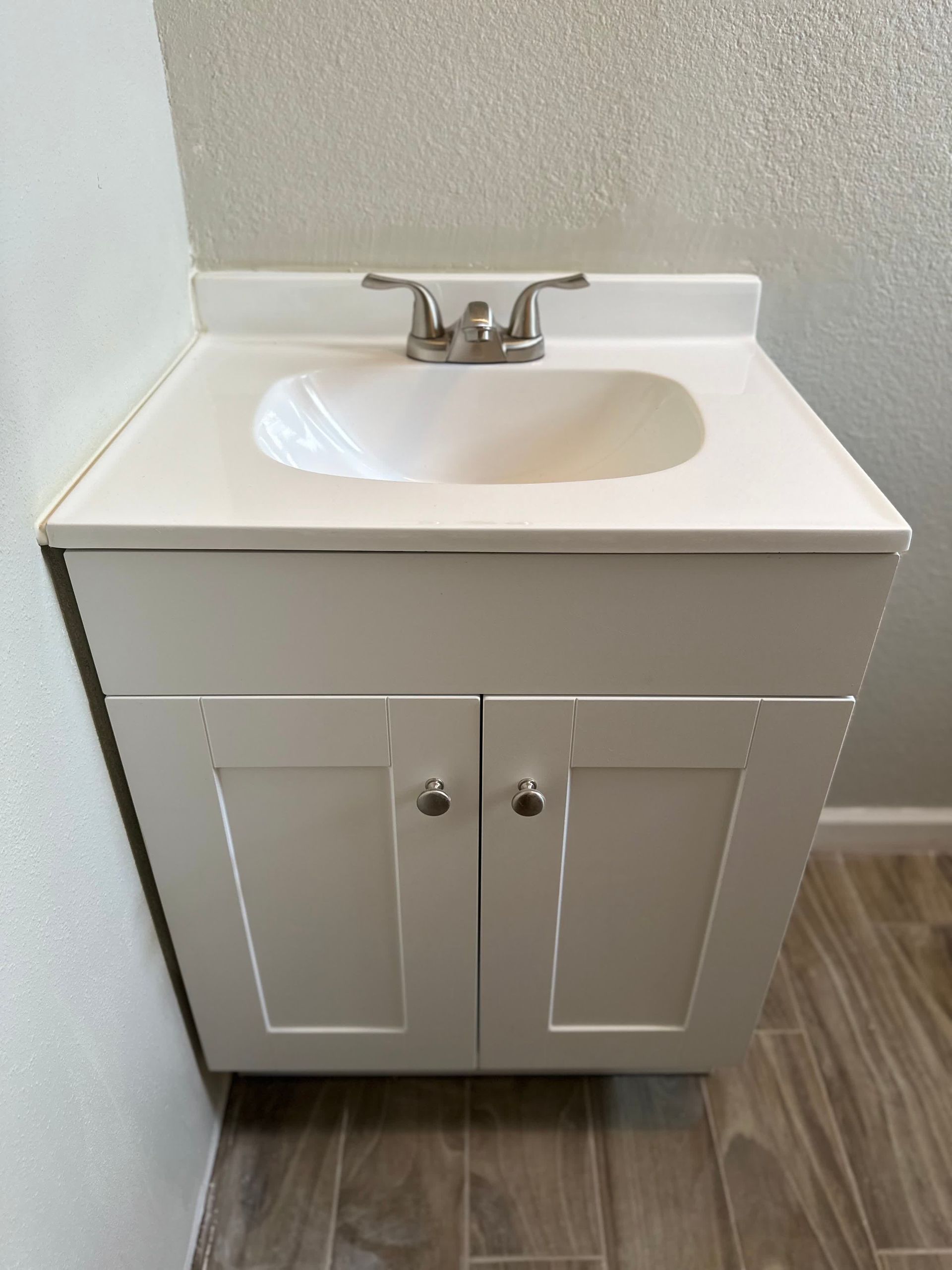 A bathroom sink with a white cabinet and a faucet.