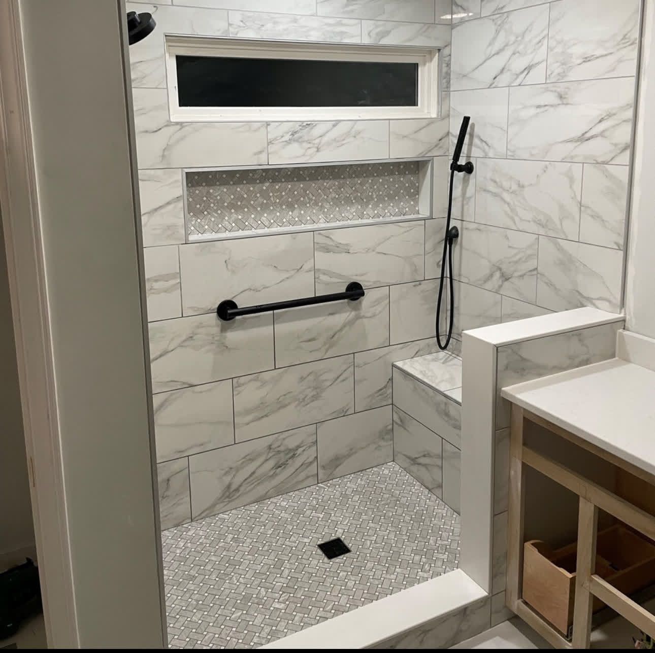 A bathroom with a walk in shower and a sink.