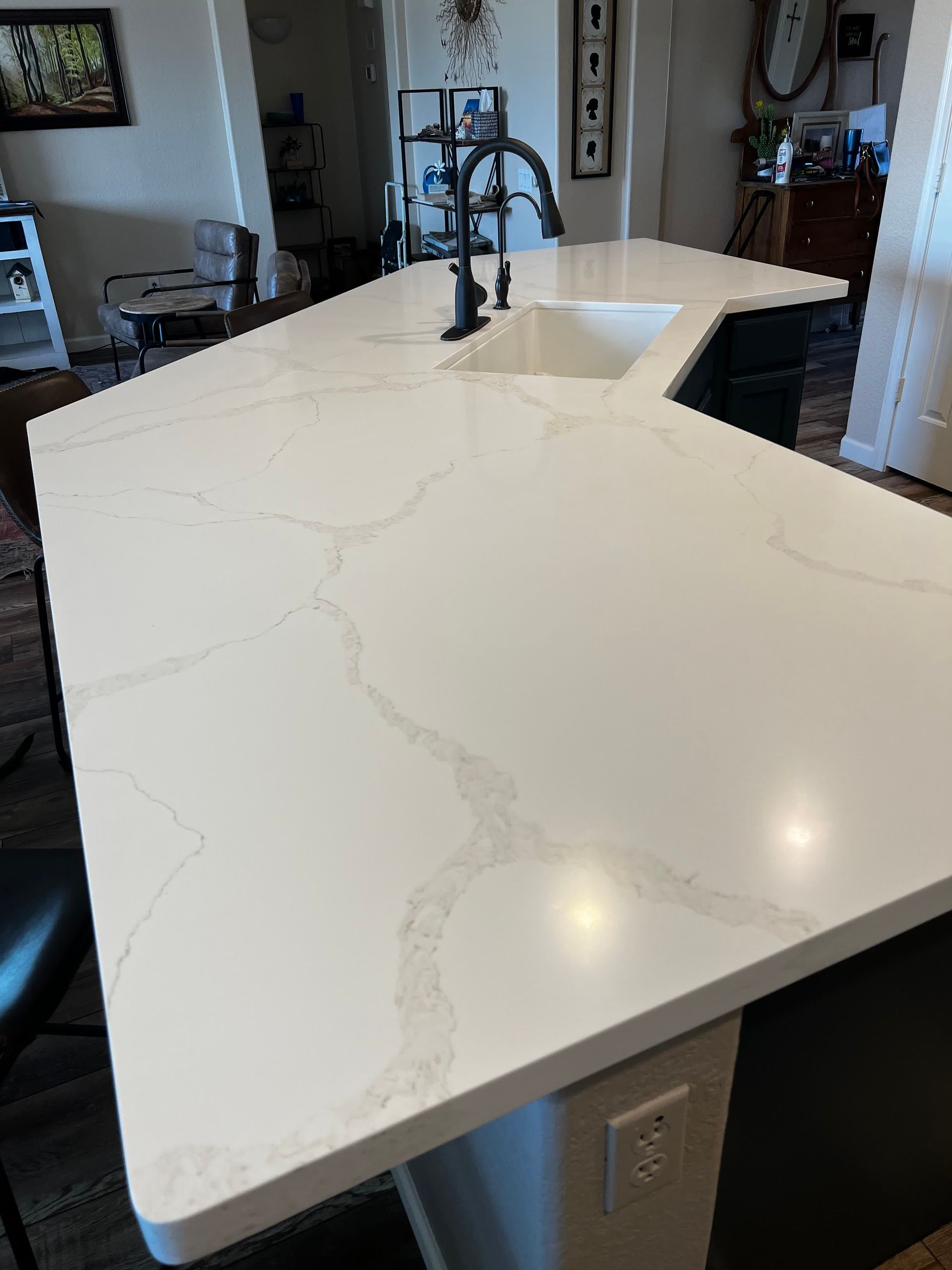 A kitchen with a large white counter top and a sink.