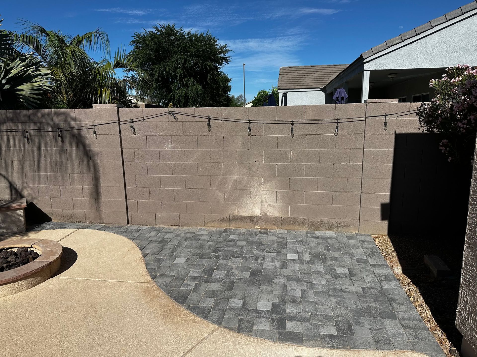 A backyard with a brick wall and a fire pit