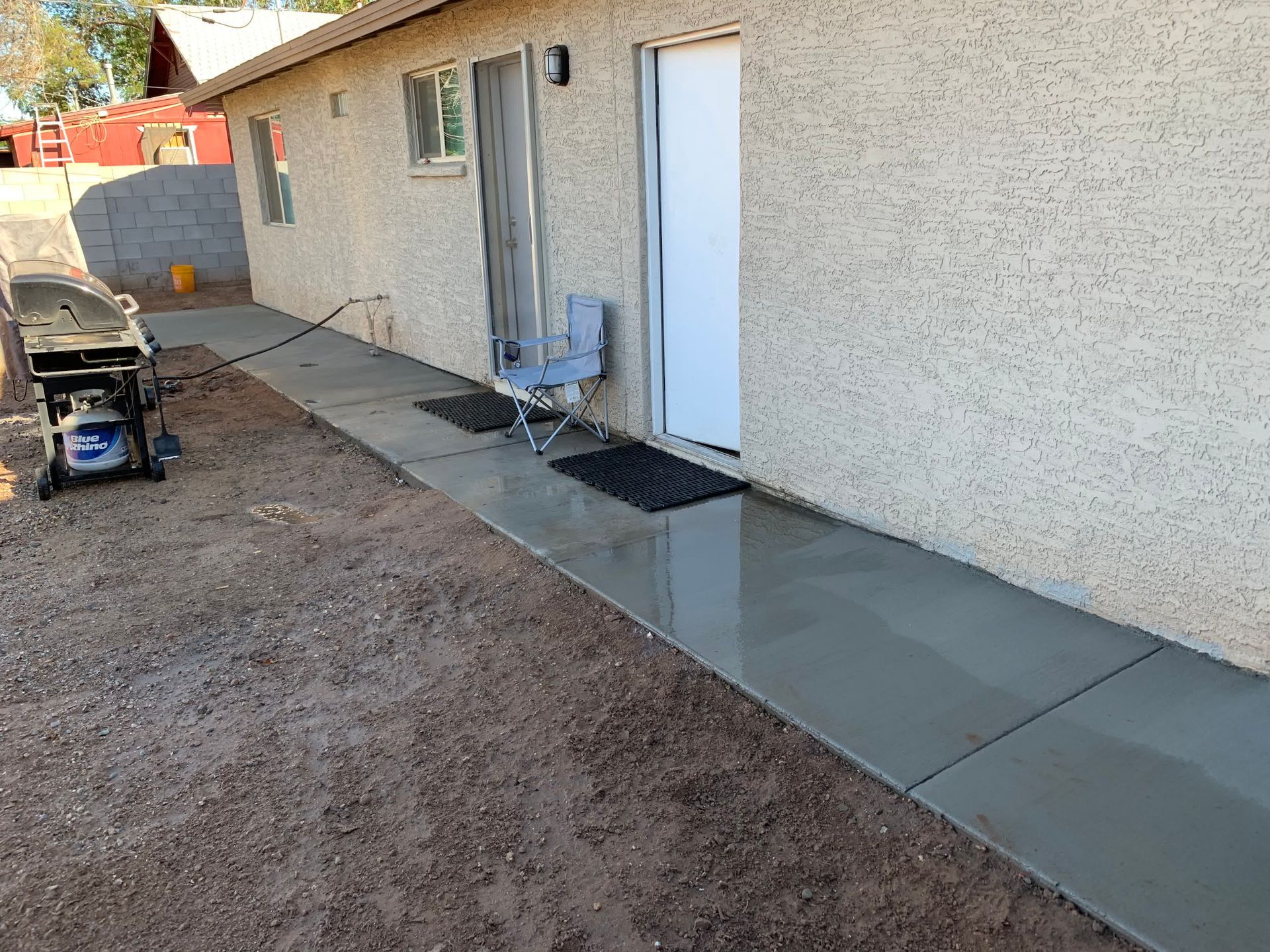 A concrete walkway is being built in front of a house.