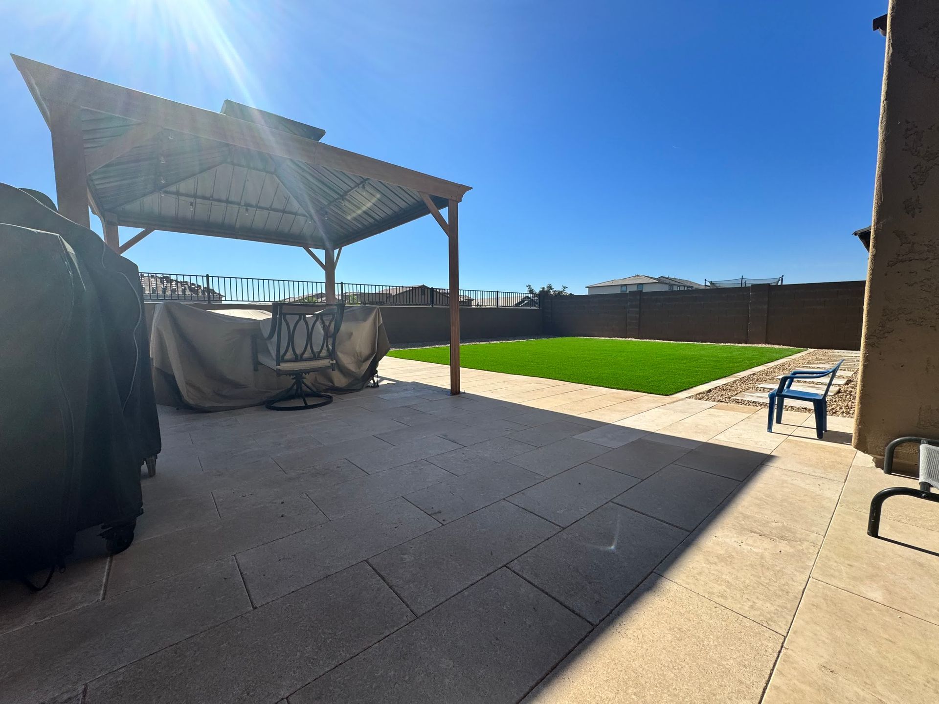 A patio with a gazebo and a lawn in the background