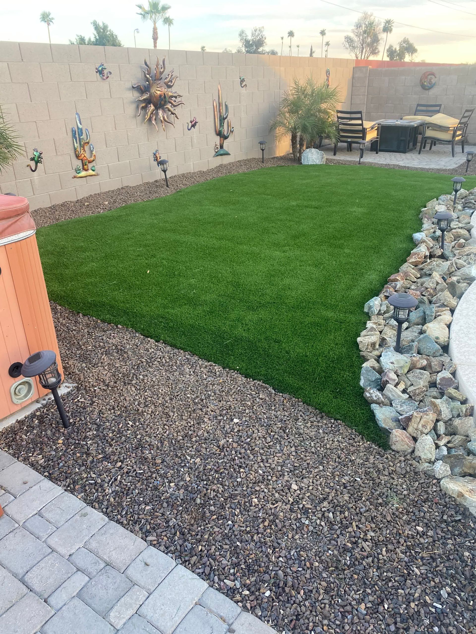 A backyard with a lot of grass and rocks