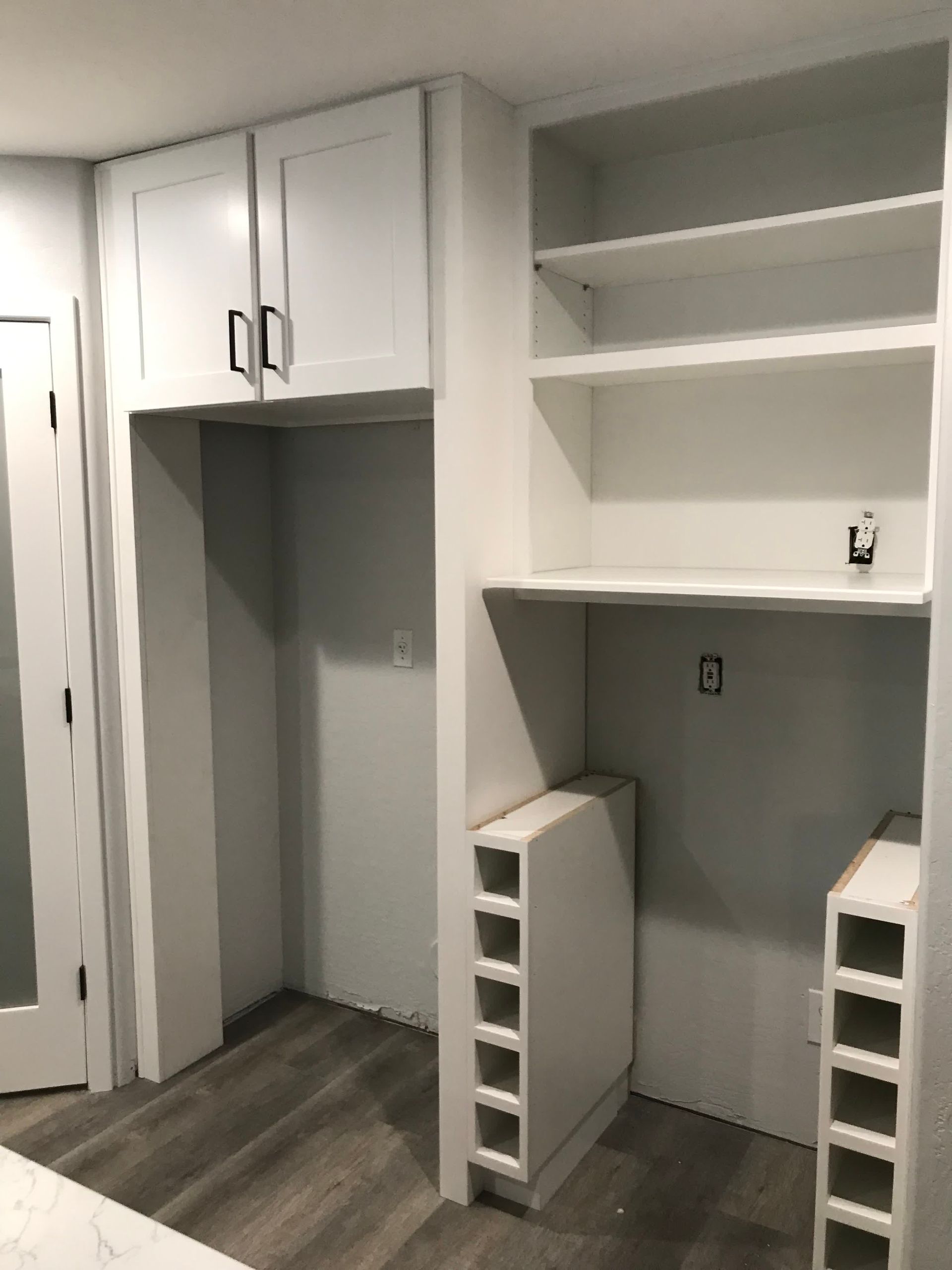A room with a lot of white cabinets and shelves