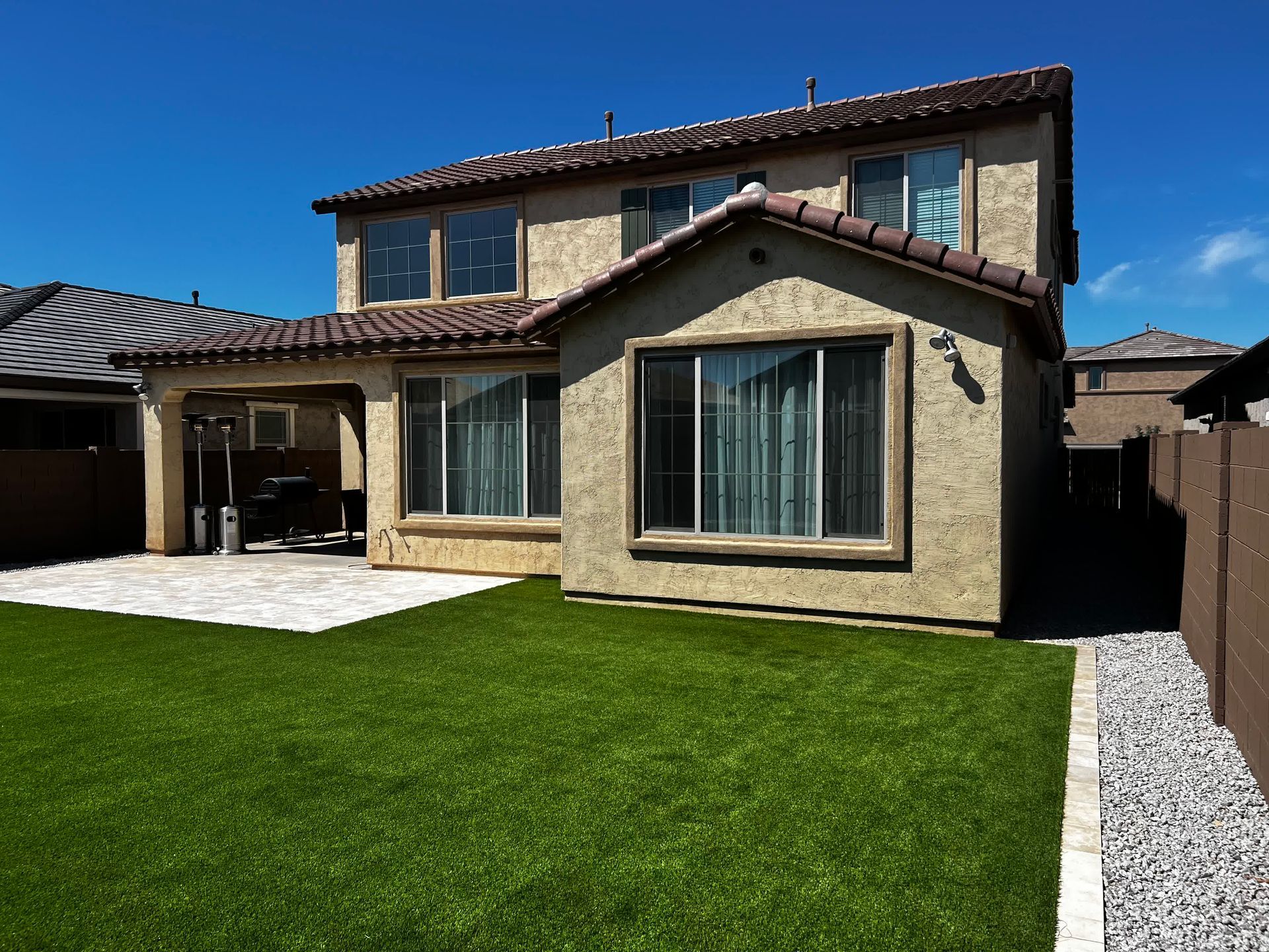 A house with a lot of windows and a lawn in front of it