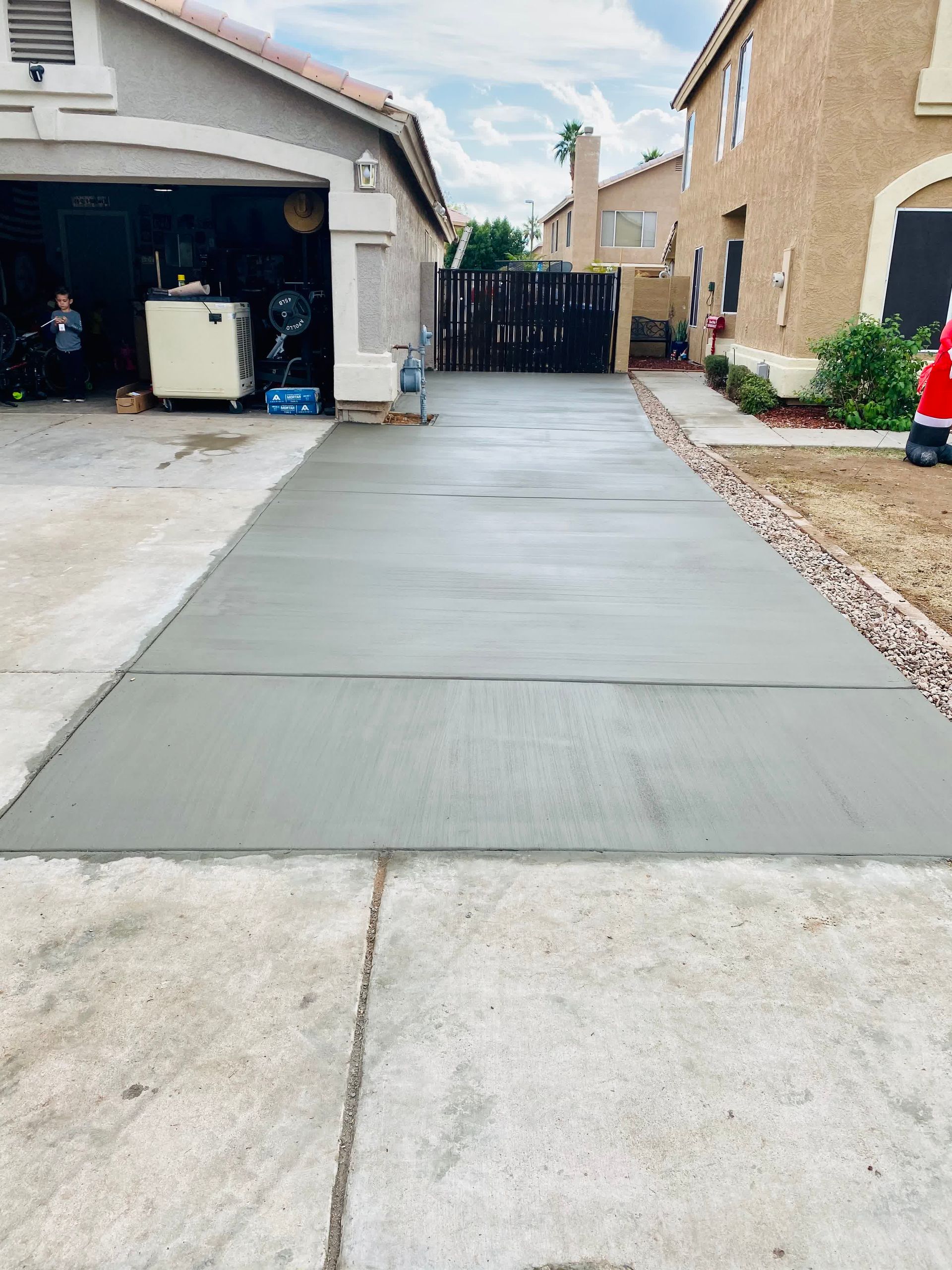 A concrete driveway is being built in front of a house.