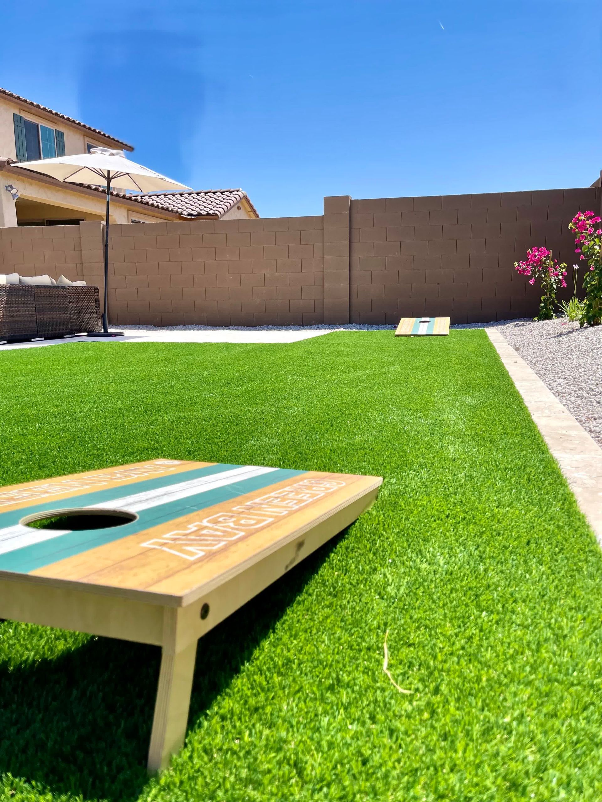 A cornhole board is sitting on top of a lush green lawn