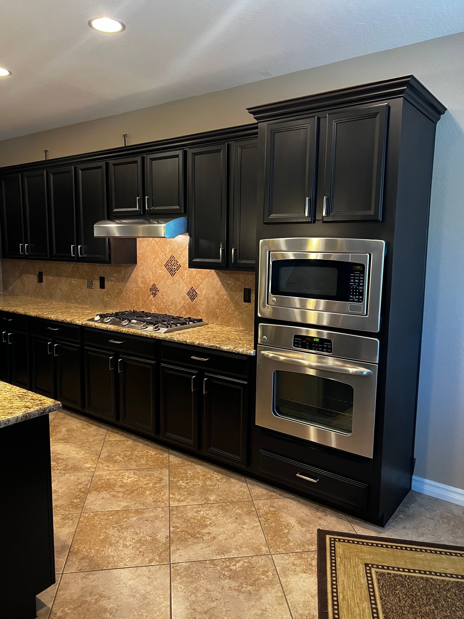 A kitchen with black cabinets and stainless steel appliances