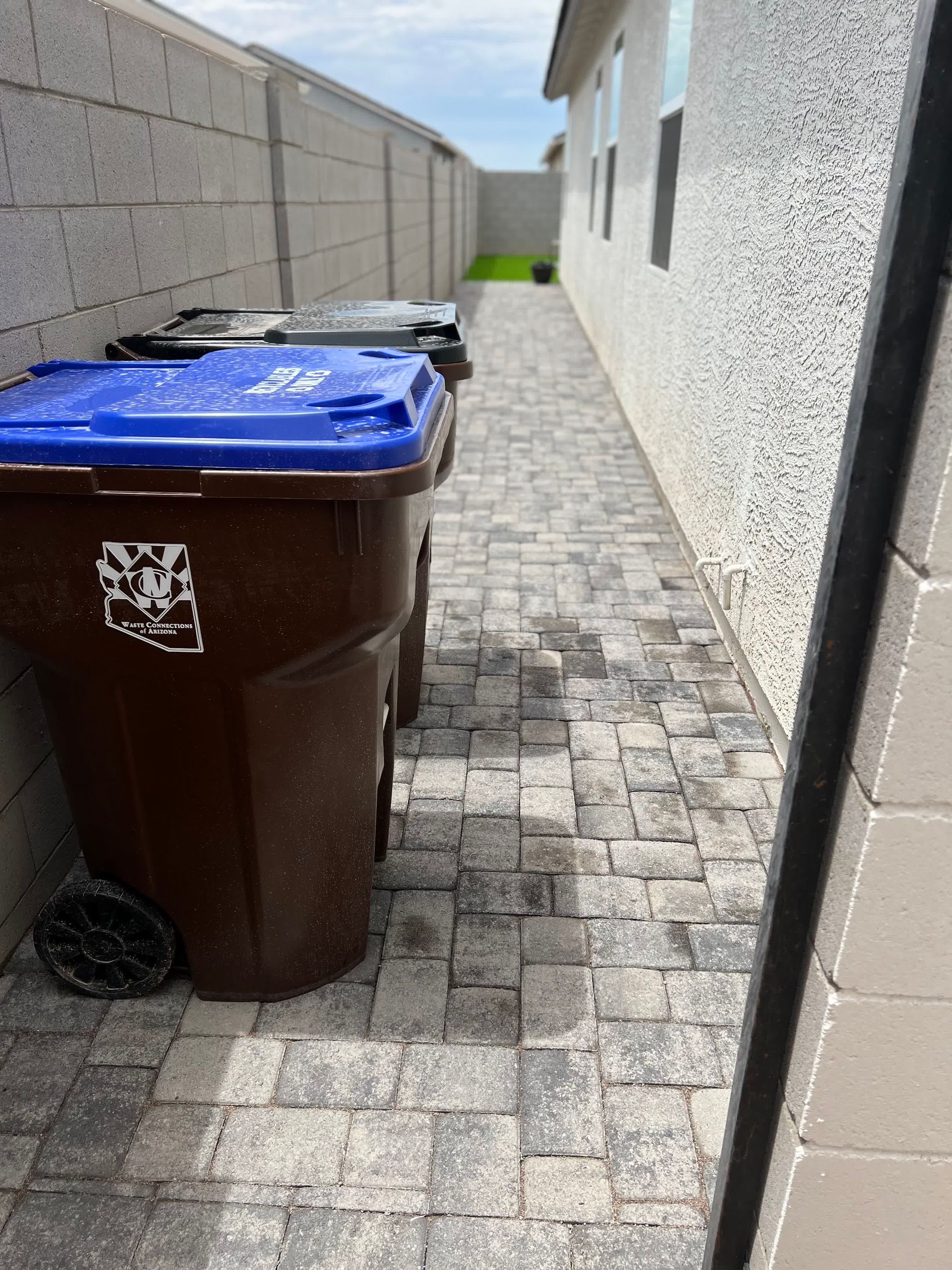 A couple of trash cans are sitting on a sidewalk next to a building.