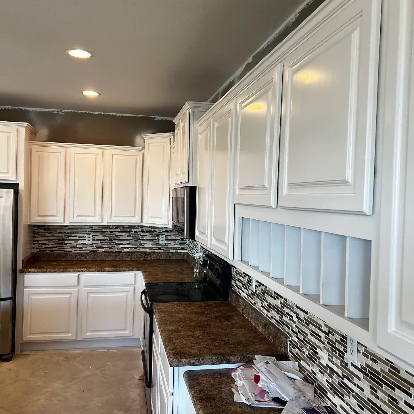 A kitchen with white cabinets and granite counter tops