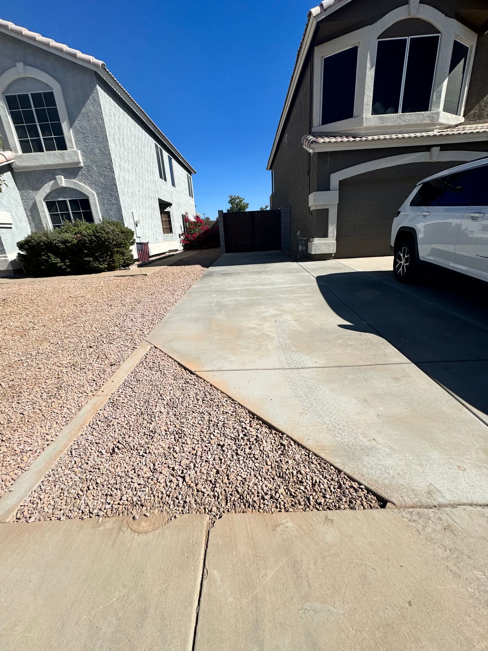 A white car is parked in front of a house.