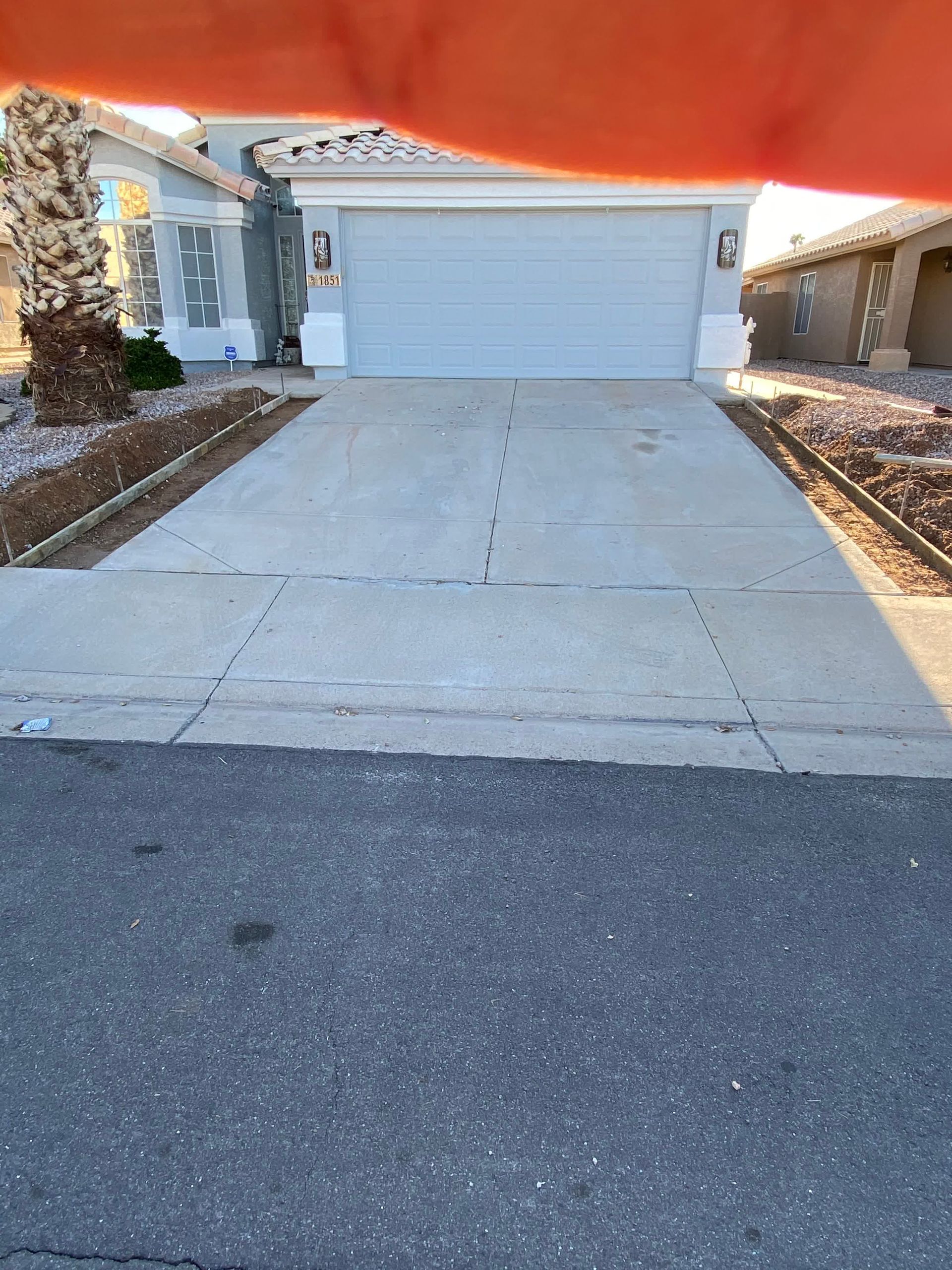 A person is pointing at a house with a white garage door