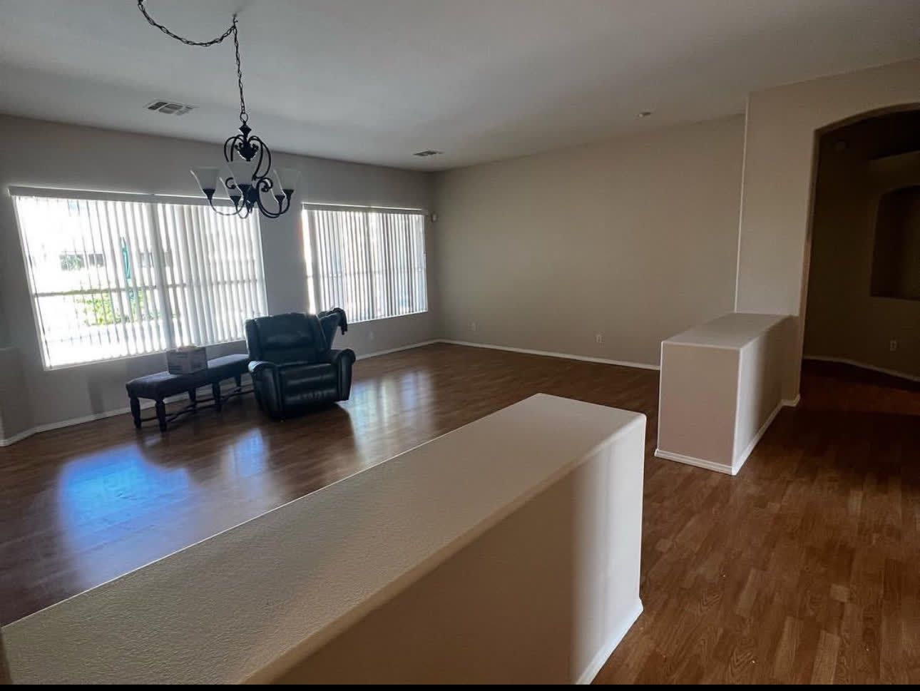 A living room with a couch , chair , table and chandelier.