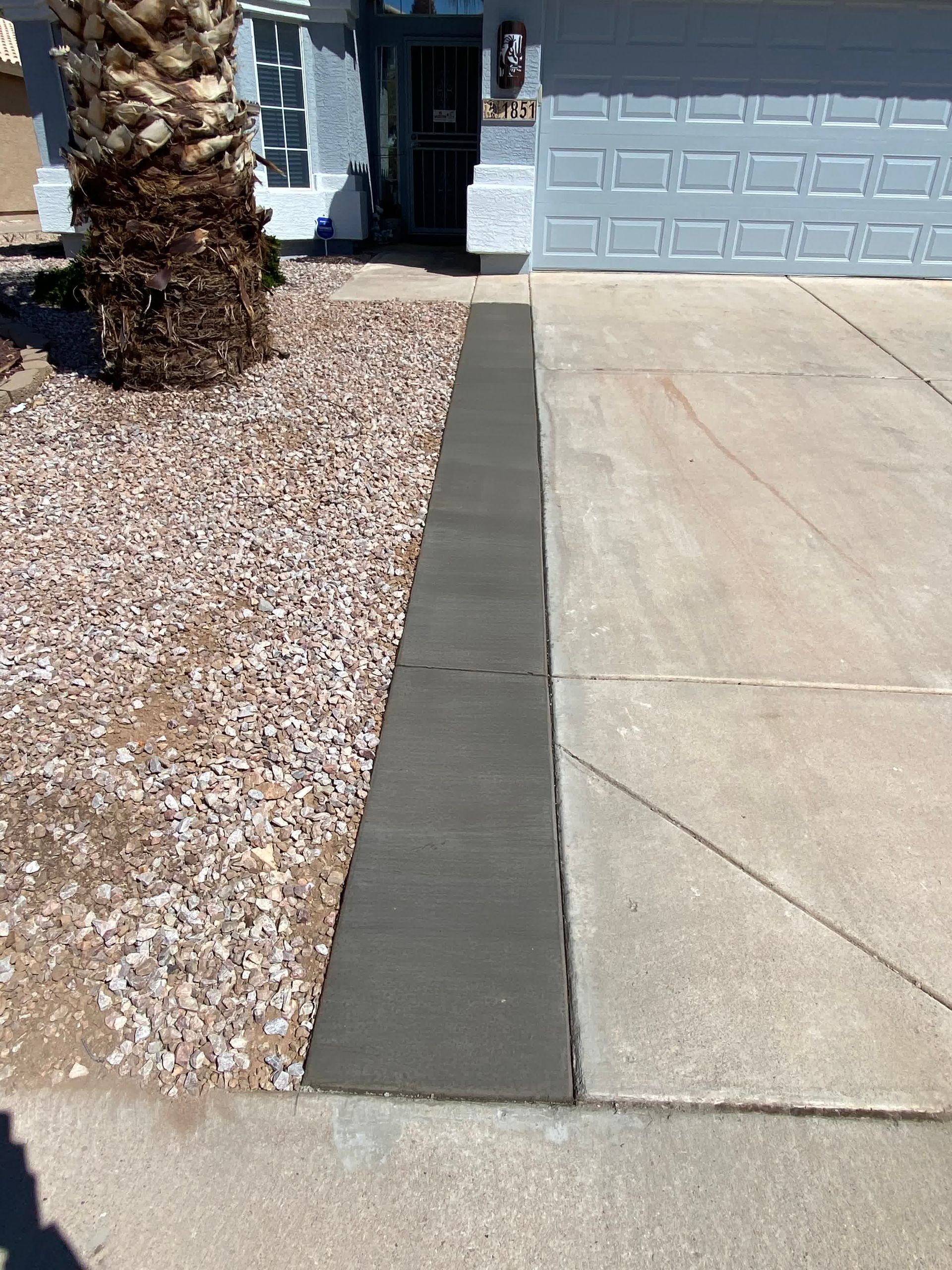 A concrete walkway is being built in front of a house.