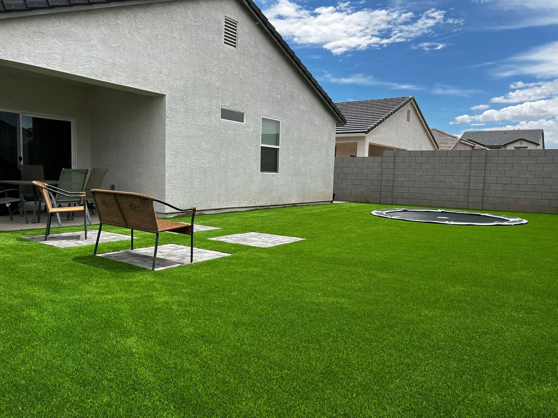 There is a trampoline in the backyard of a house.