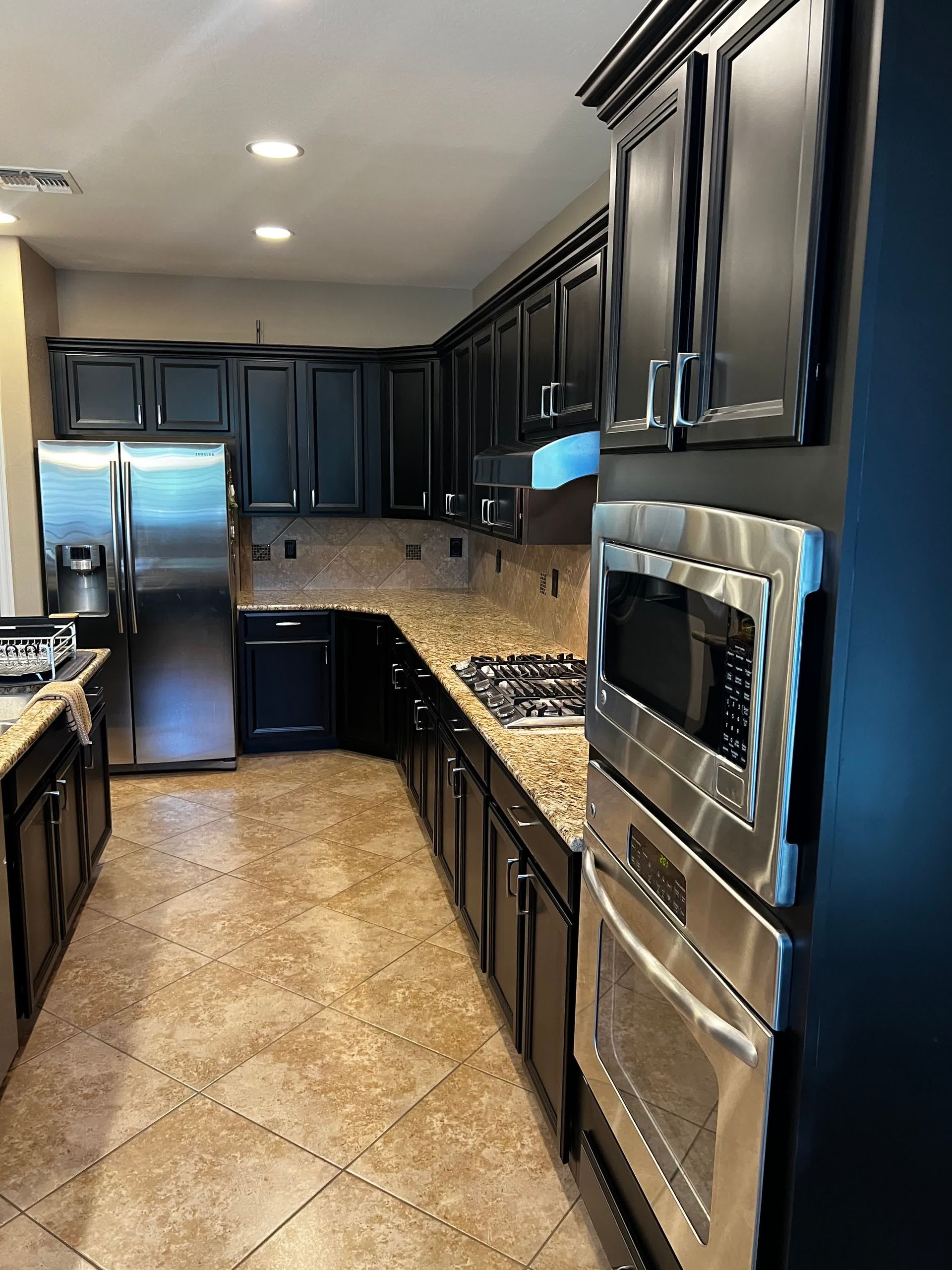 A kitchen with black cabinets and stainless steel appliances.
