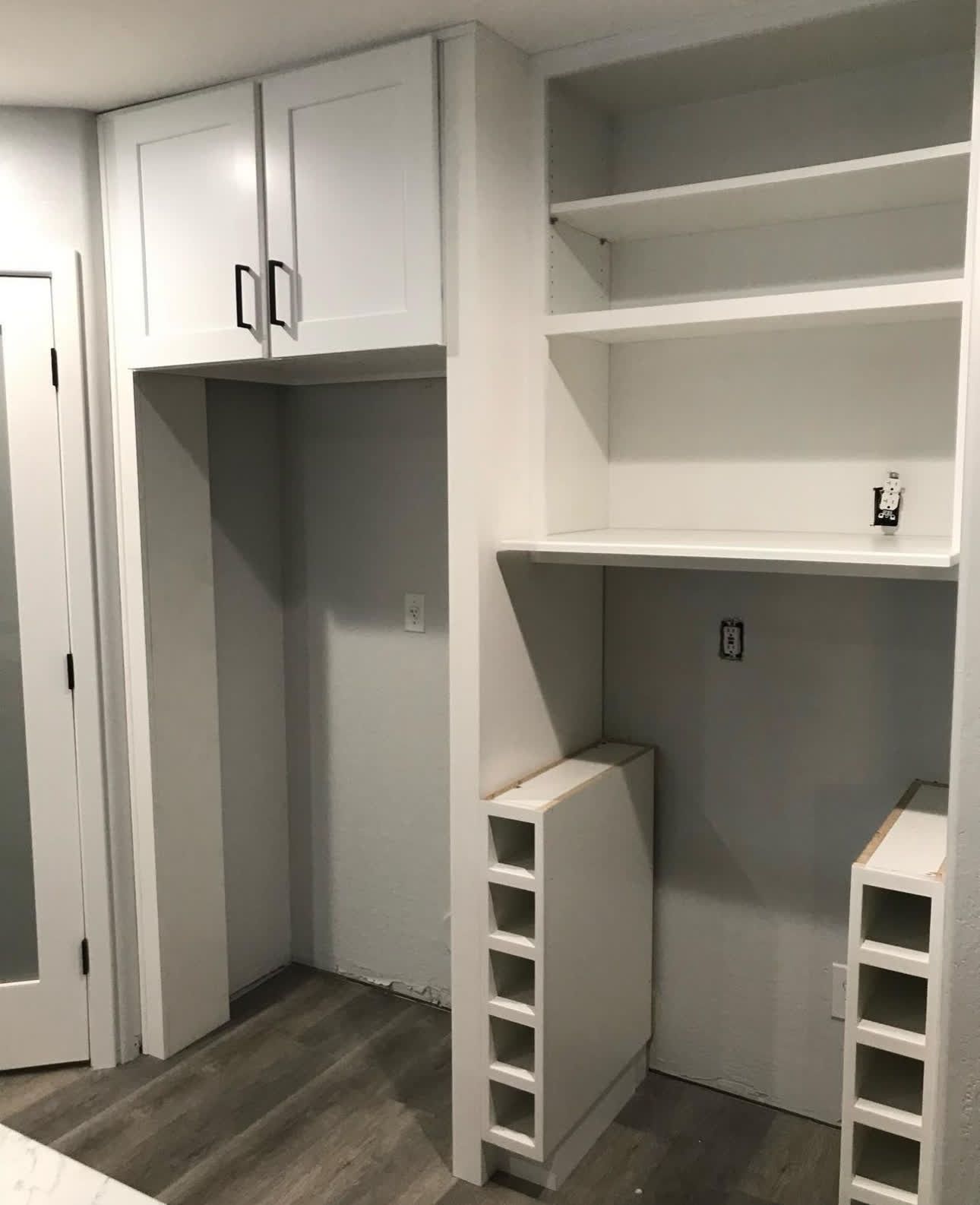A room with a lot of white cabinets and shelves