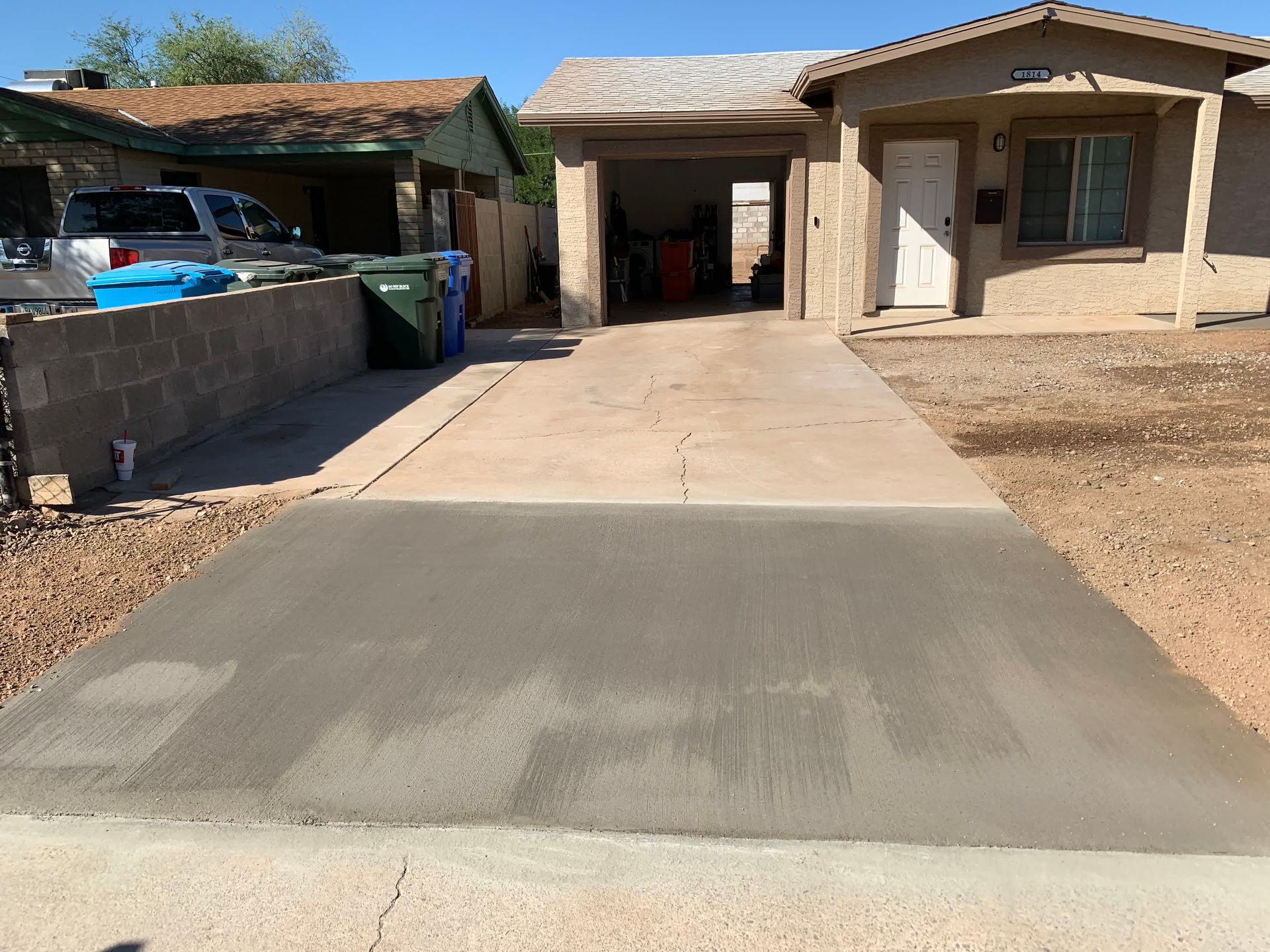 A concrete driveway is being built in front of a house