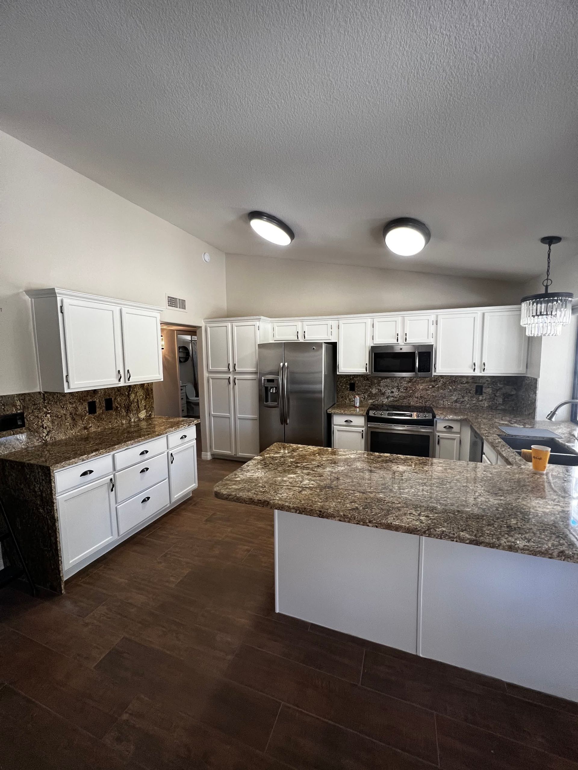 A kitchen with white cabinets and granite counter tops