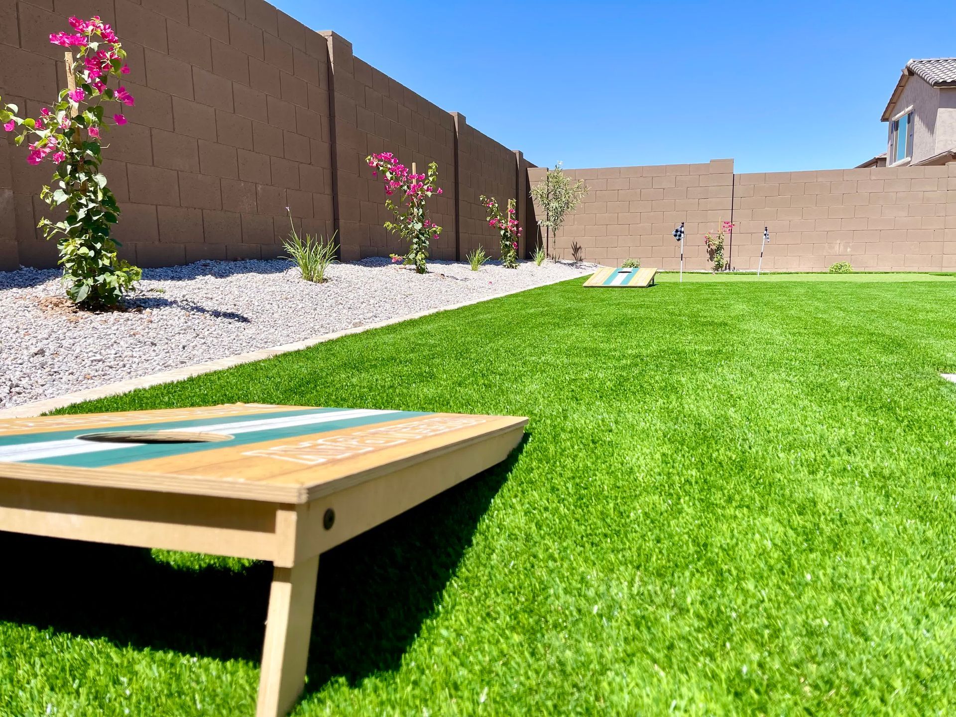 A cornhole board is sitting on top of a lush green lawn.