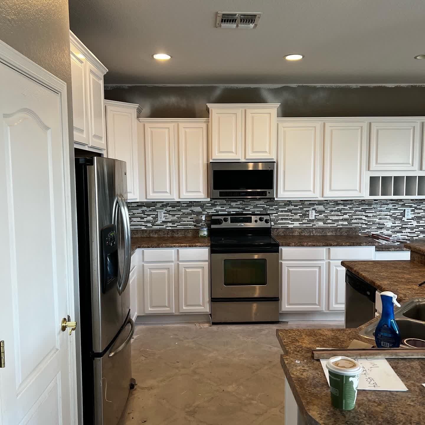 A kitchen with white cabinets and stainless steel appliances