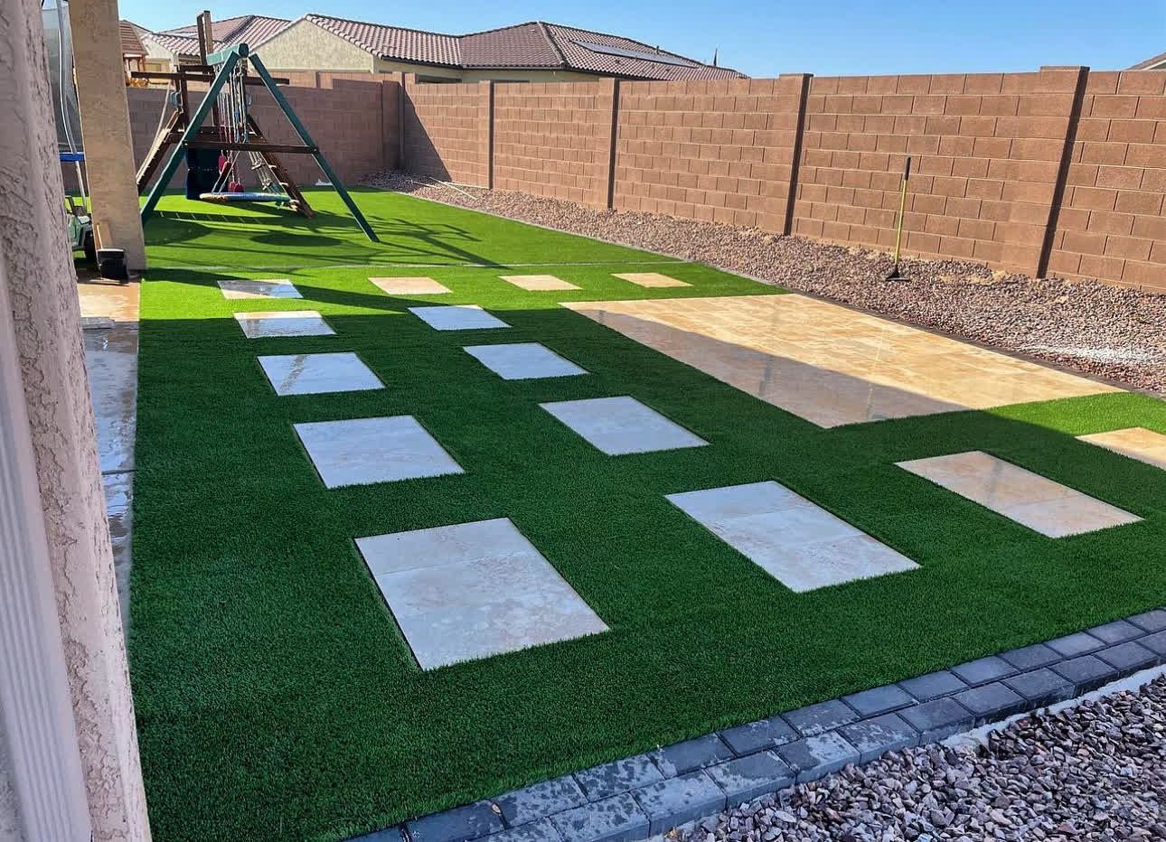A backyard with a swing set and stepping stones.