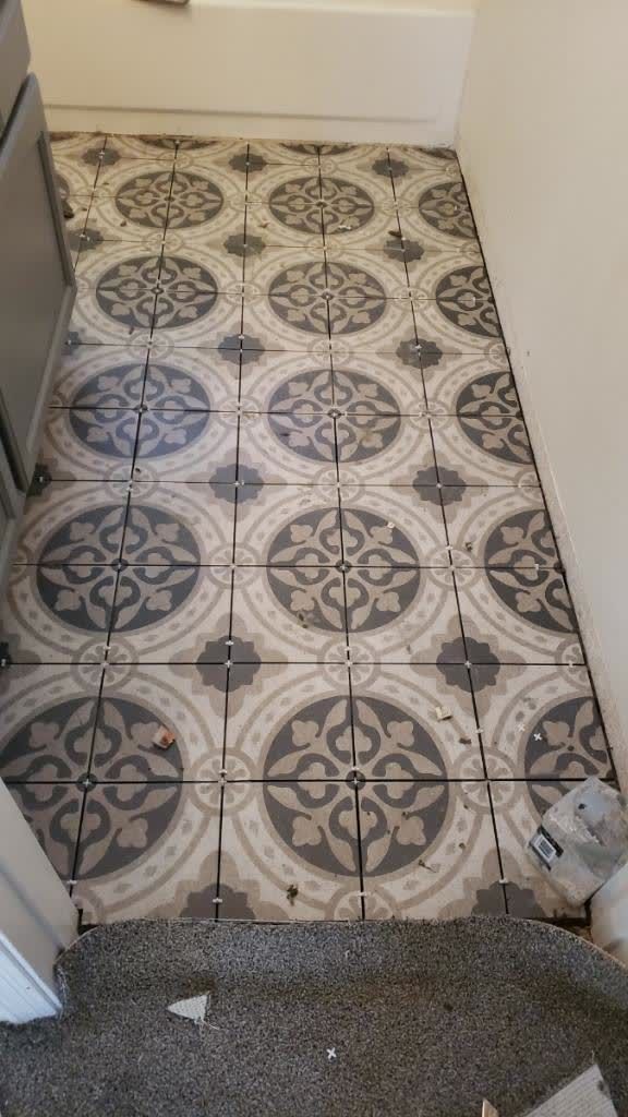 A tiled floor with a pattern on it in a bathroom.