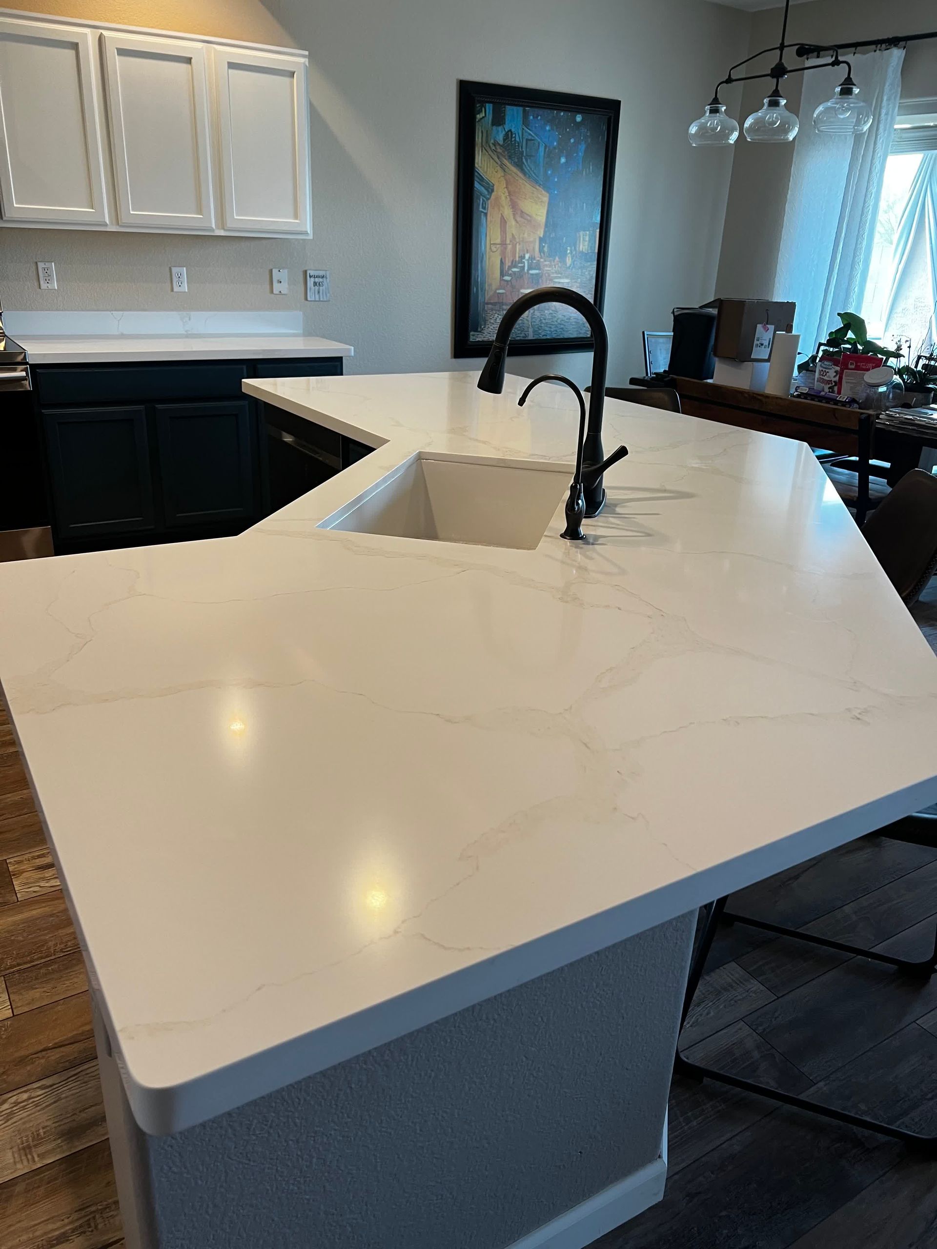 A kitchen with a large white counter top and a sink.