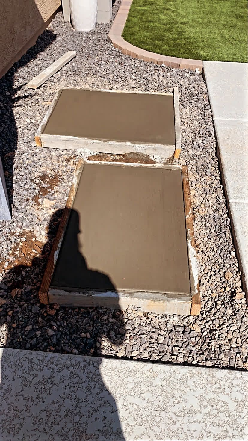 A couple of concrete slabs sitting on top of a pile of gravel.