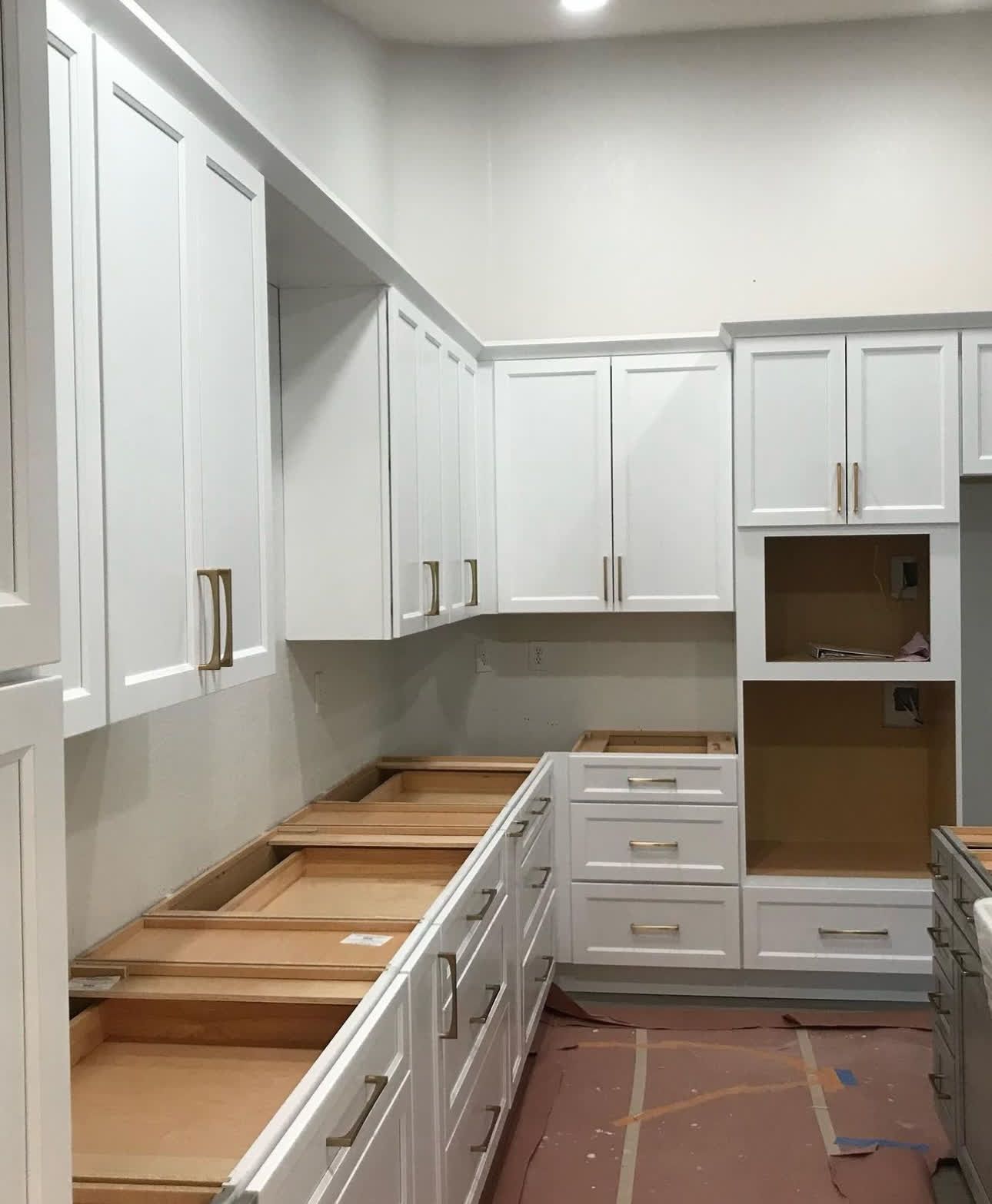 A kitchen with white cabinets and drawers is being remodeled.