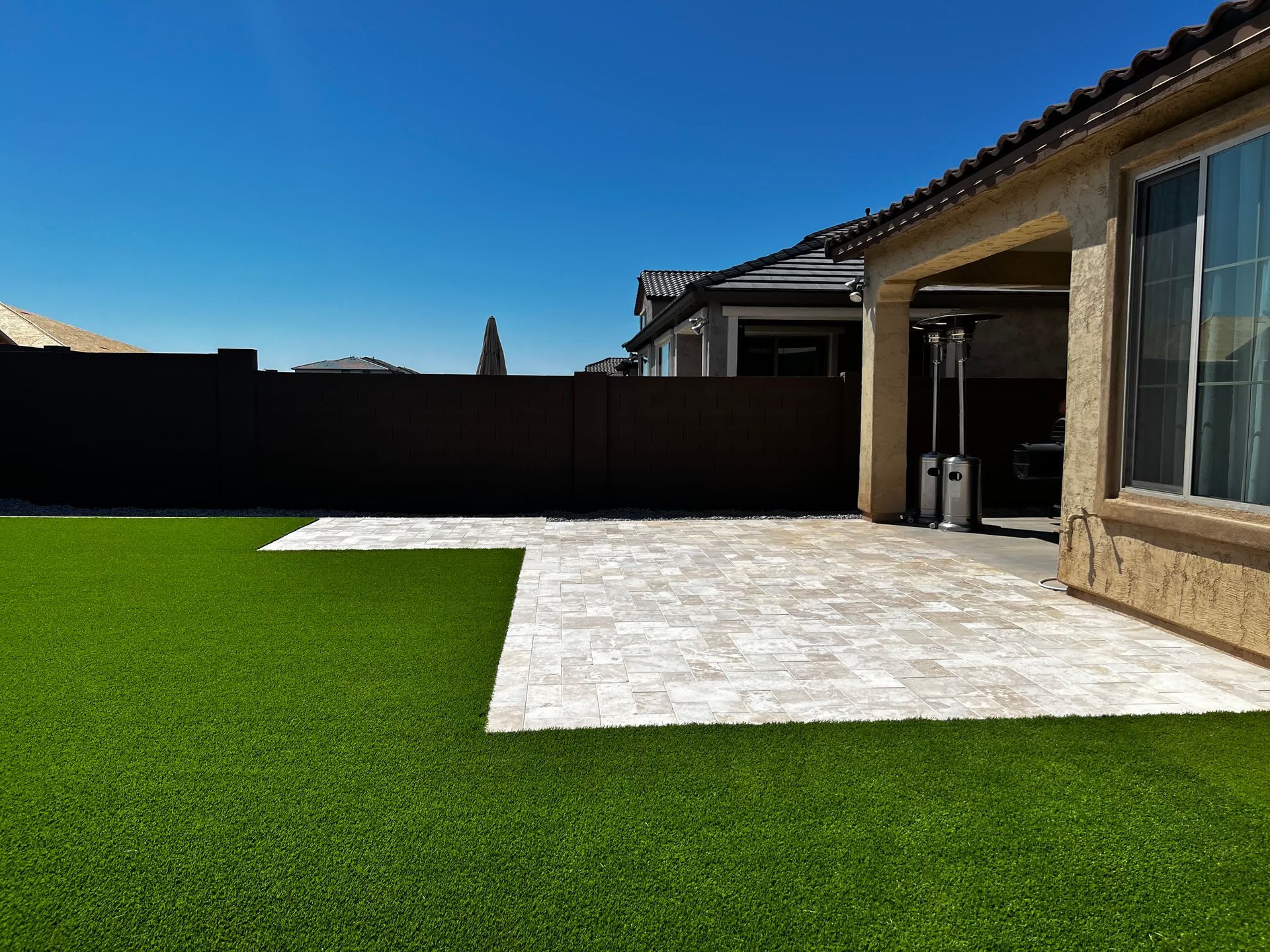 A house with a patio and a lawn in front of it.