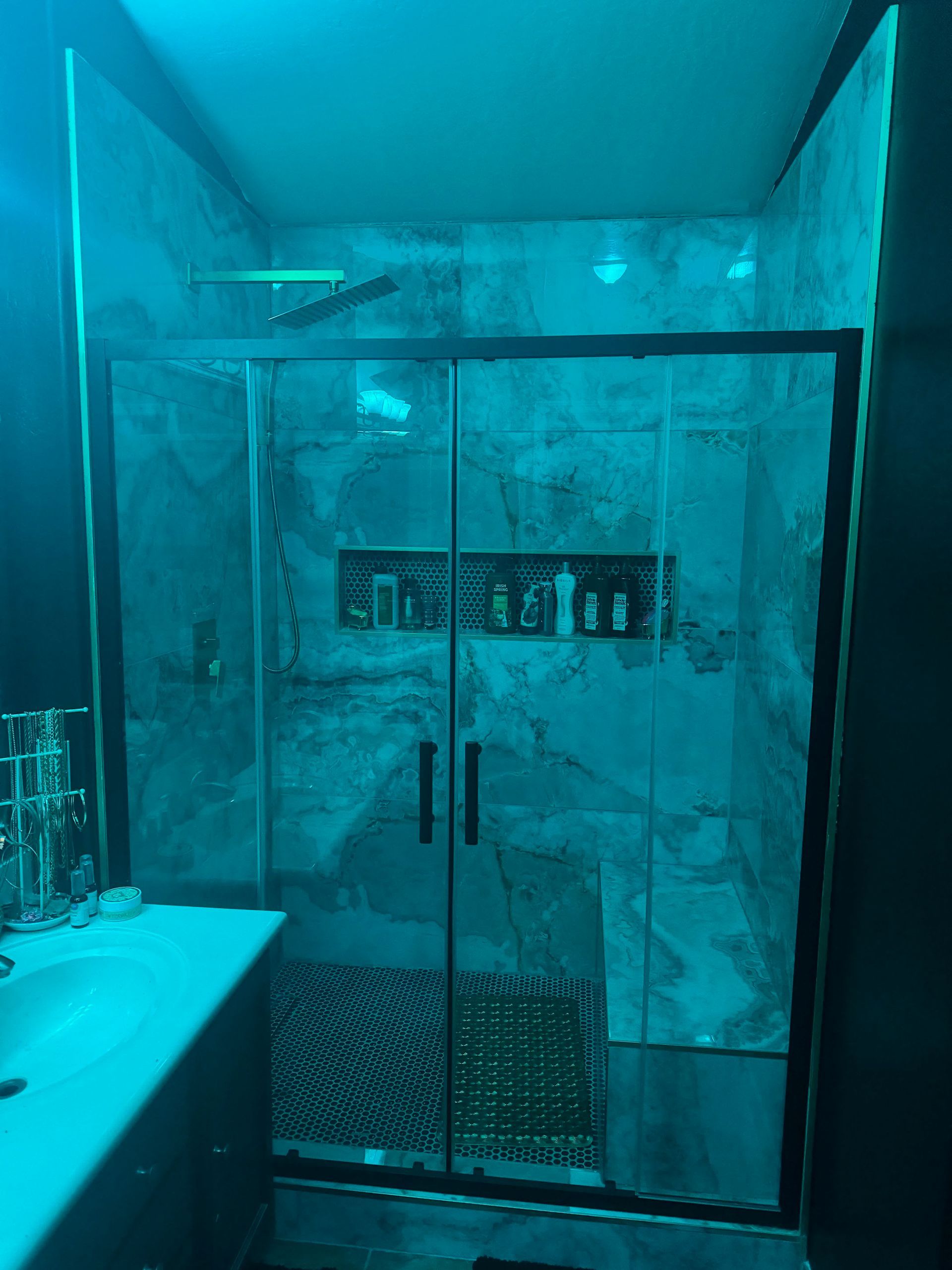 A bathroom with a sliding glass shower door and a sink.