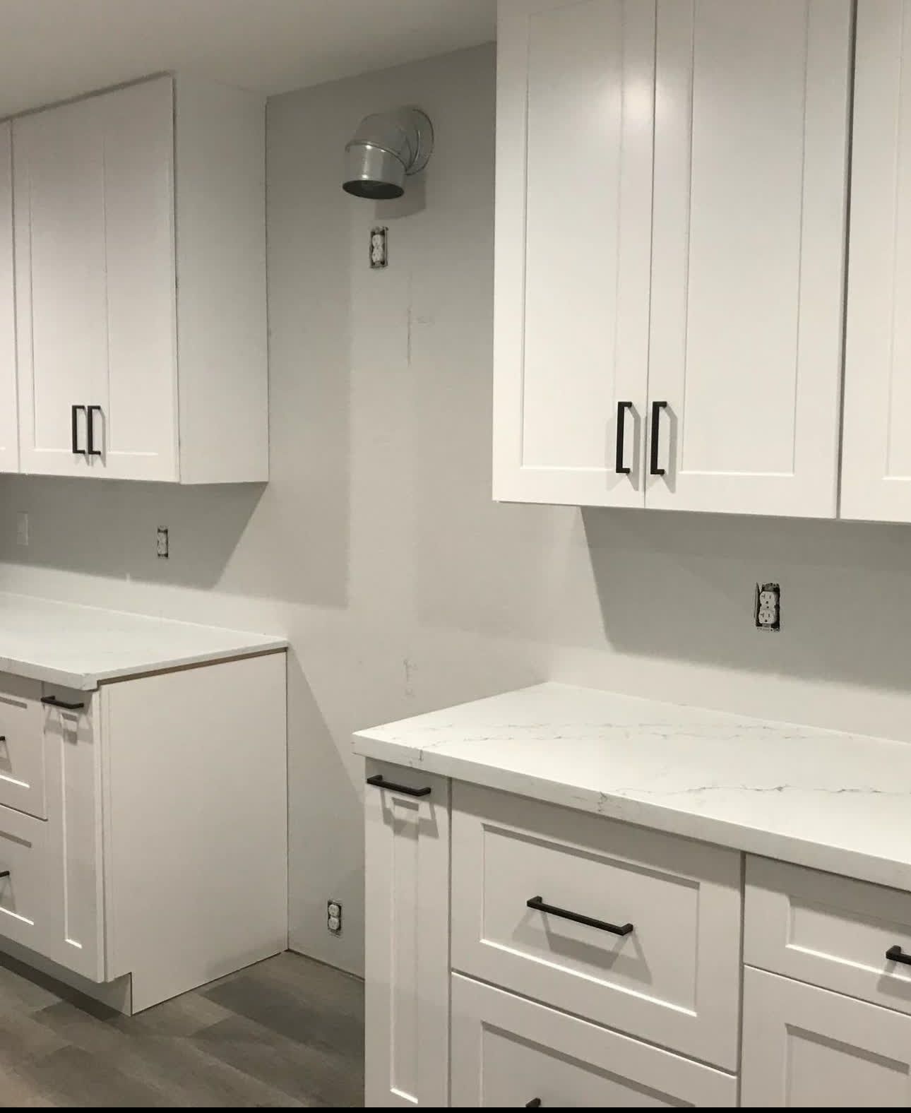 A kitchen with white cabinets and white counter tops
