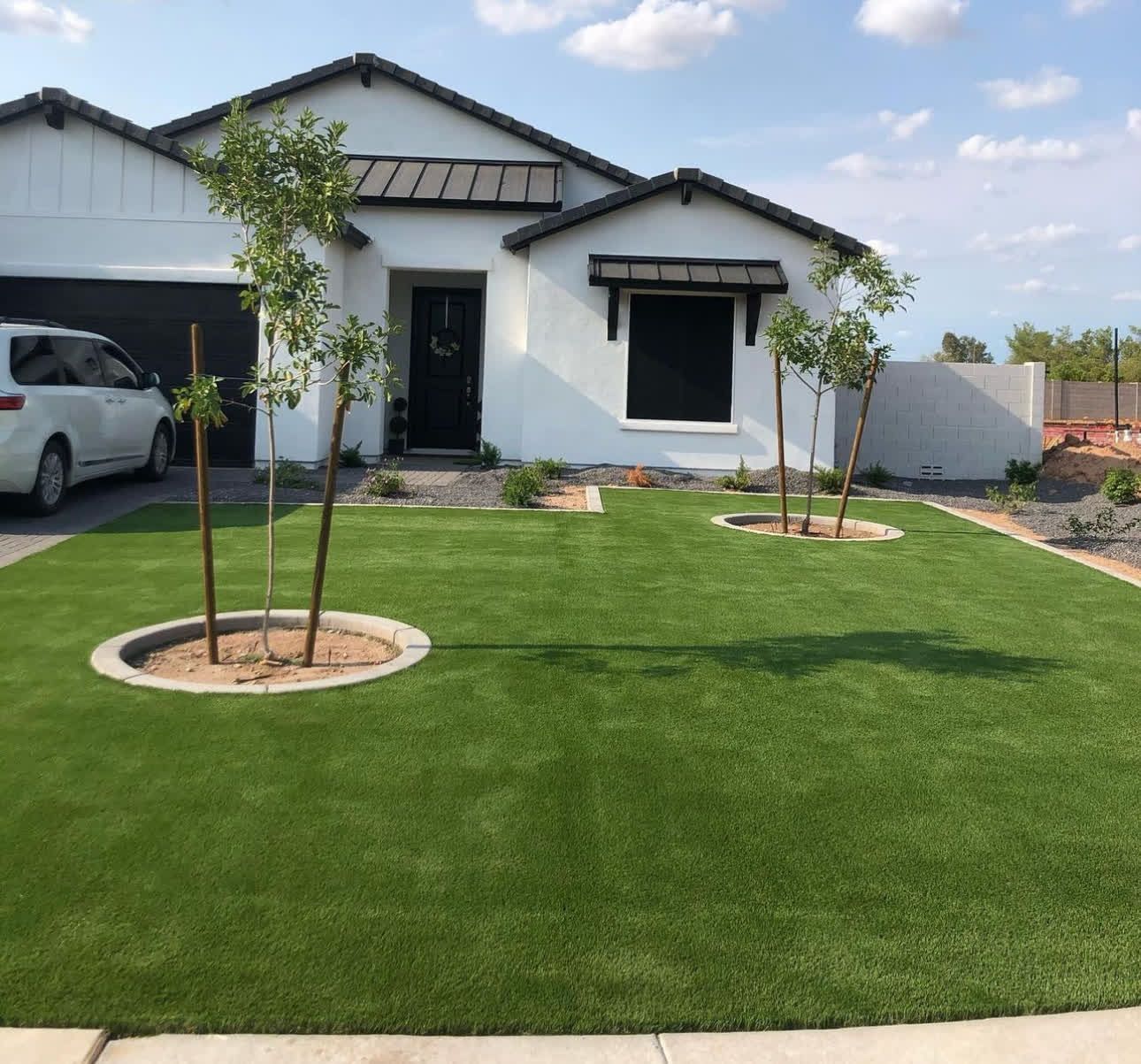 A white van is parked in front of a white house