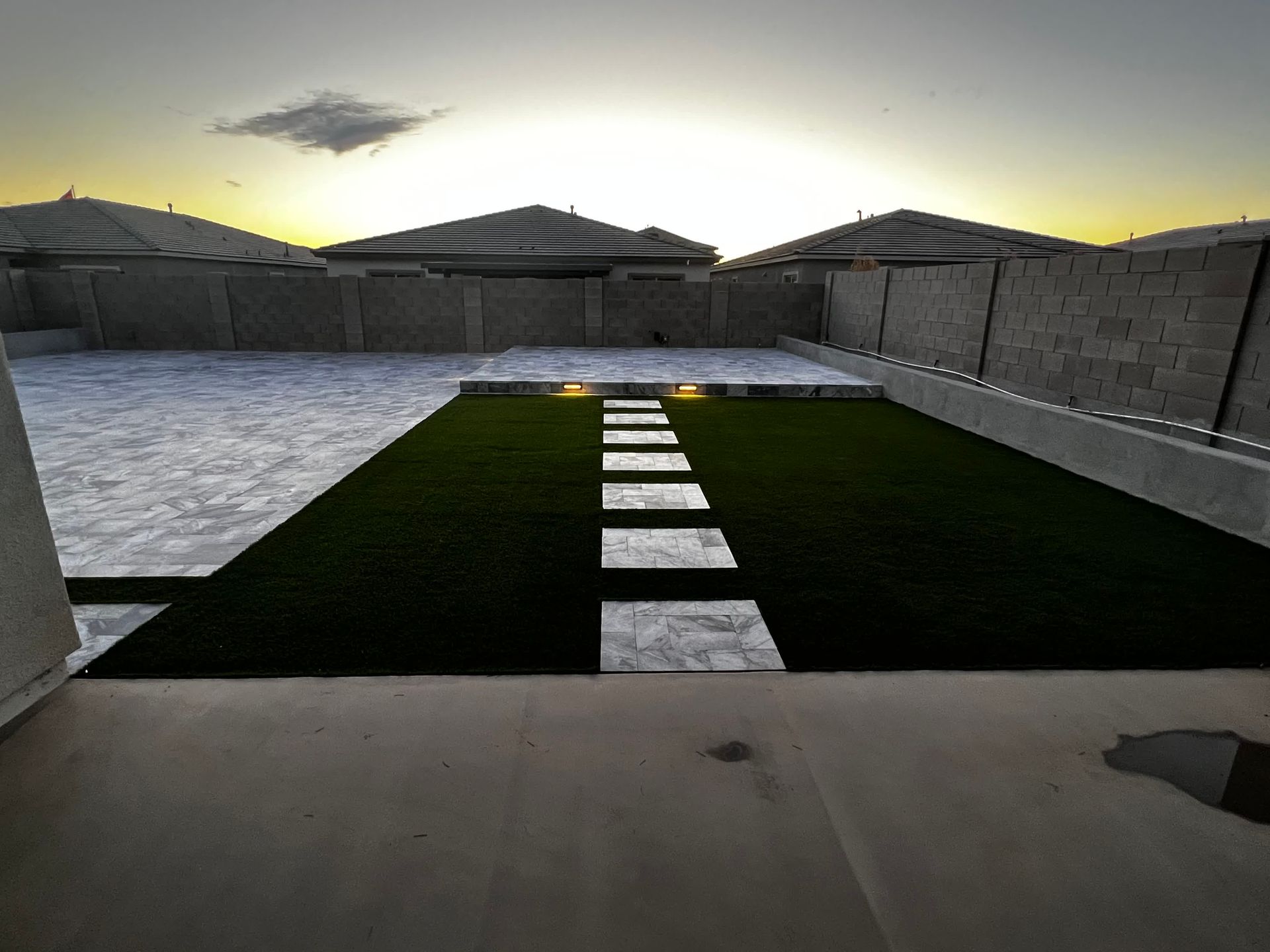 A walkway leading to a pool with a sunset in the background