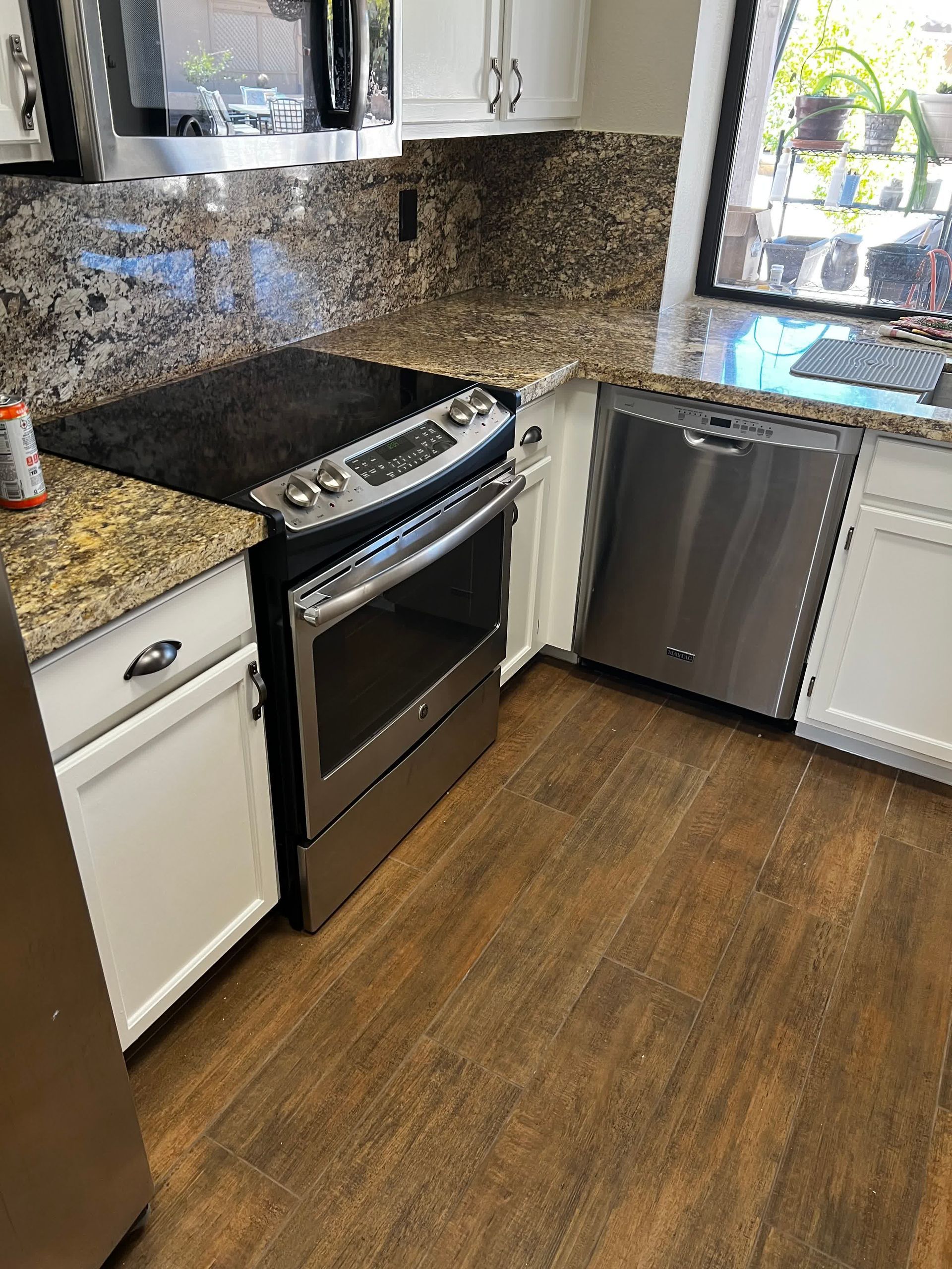 A kitchen with stainless steel appliances and granite counter tops.