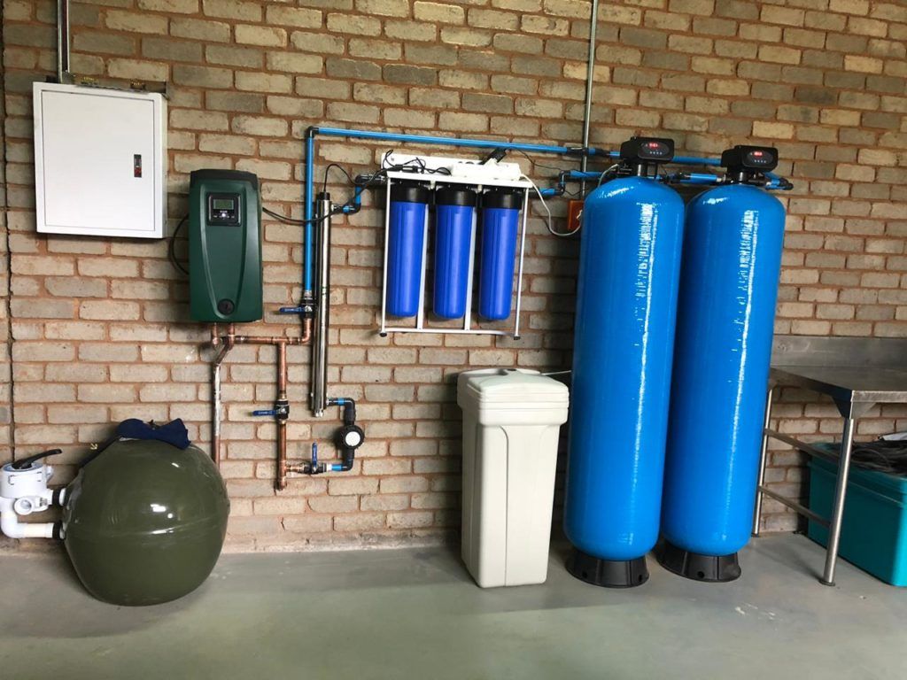 Two blue tanks are sitting next to each other in a room with a brick wall.