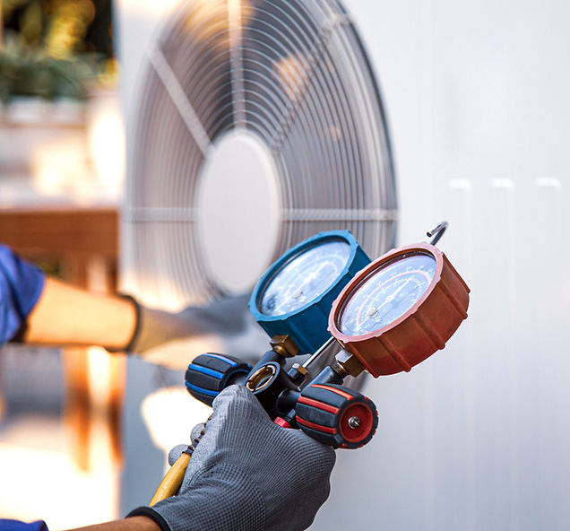 A person is holding a gauge in front of a fan.