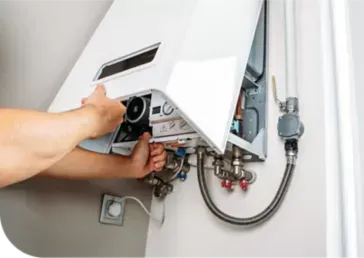 A person is fixing a water heater on a wall.