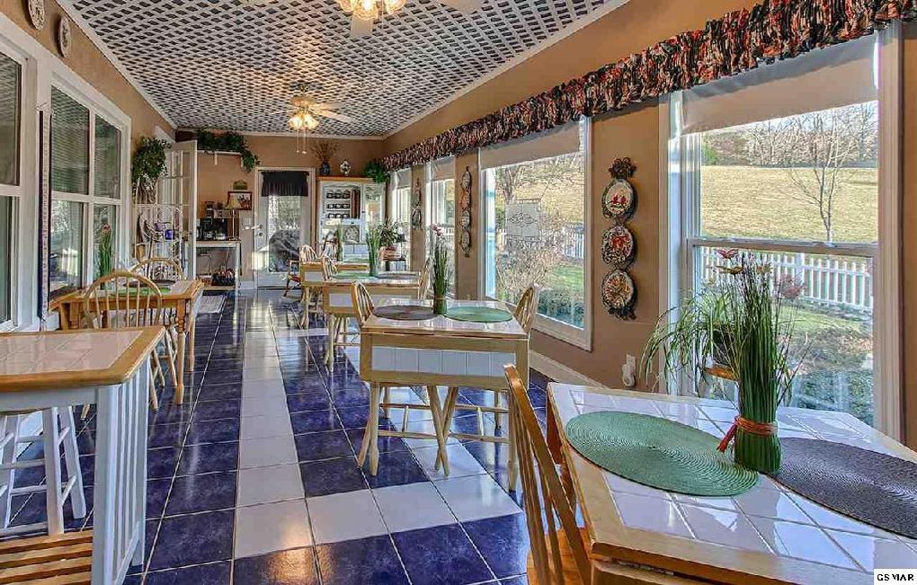 A large room with tables and chairs and a lot of windows.