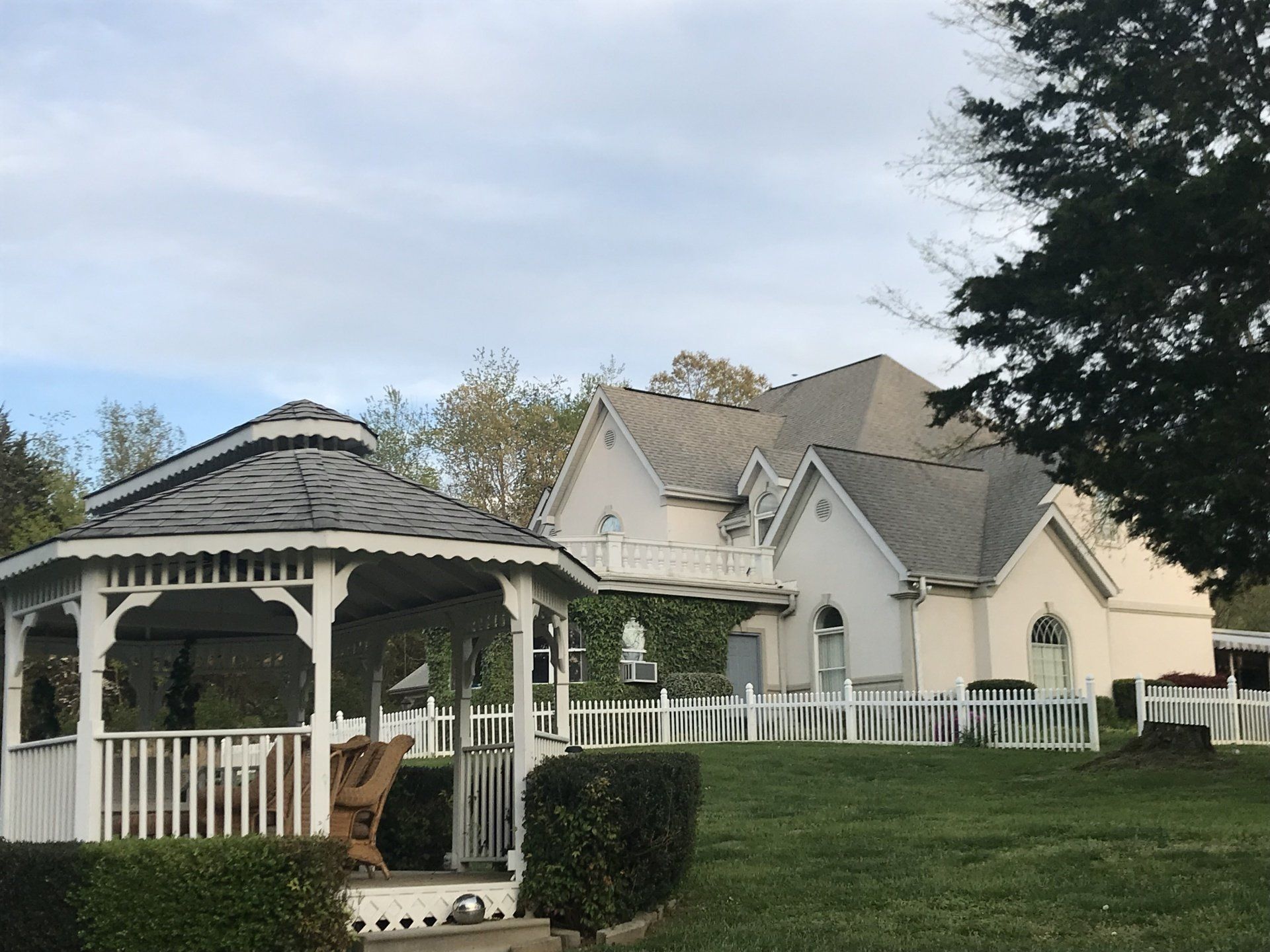 A large white house with a gazebo in front of it