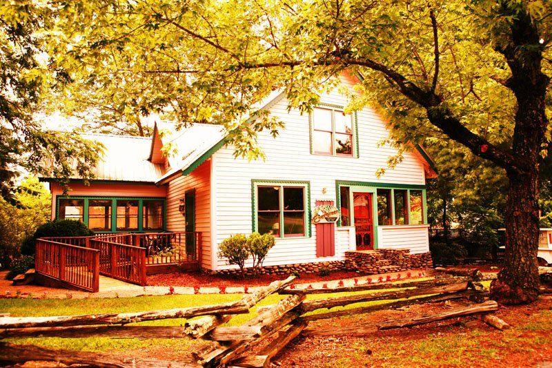 A white house with green trim and a red door