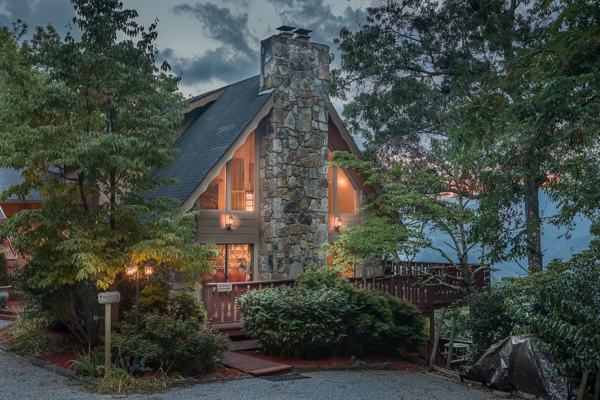 A house with a large stone chimney is lit up at night.