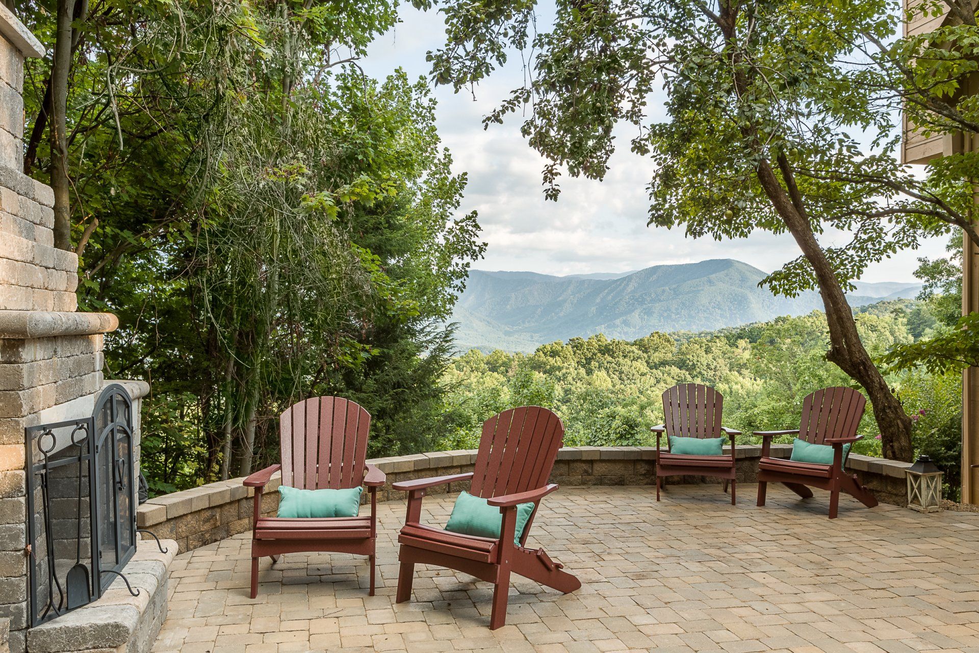 A patio with chairs and a fireplace with a view of the mountains.