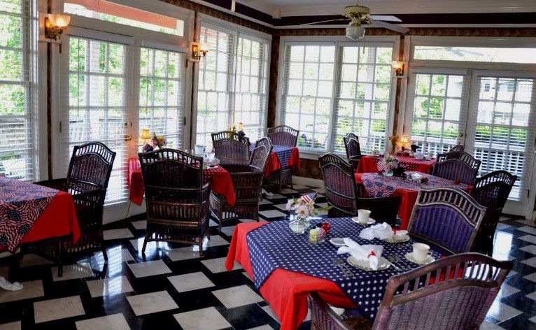 A restaurant with tables and chairs and a checkered floor.