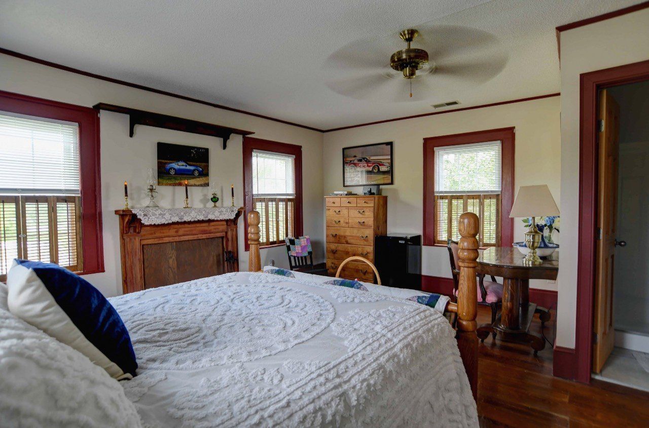 A bedroom with a large bed and a fireplace